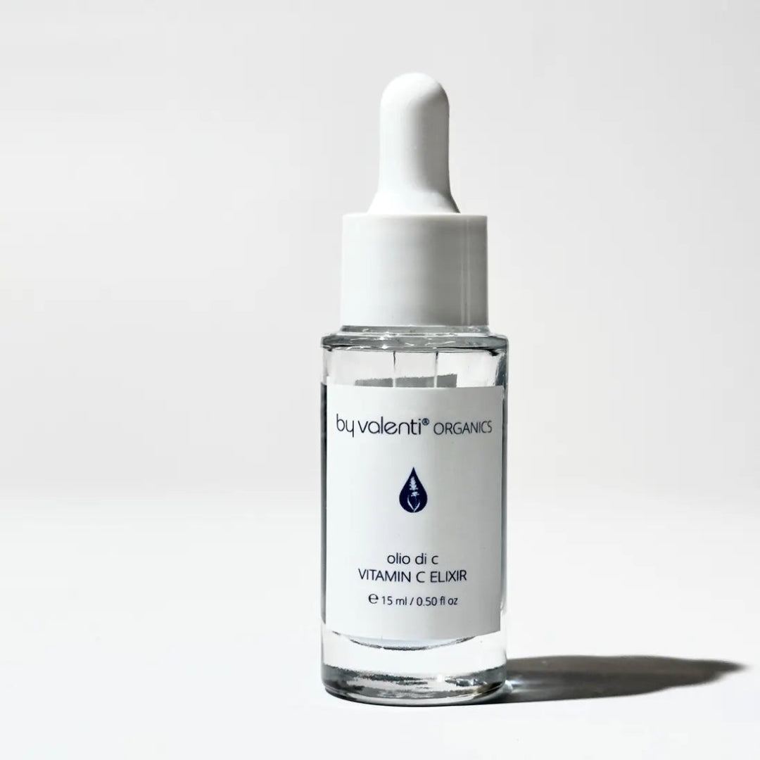 A clear glass bottle with a white dropper, labeled 'by valenti ORGANICS VITAMIN C ELIXIR'. The bottle is displayed against a white background.
