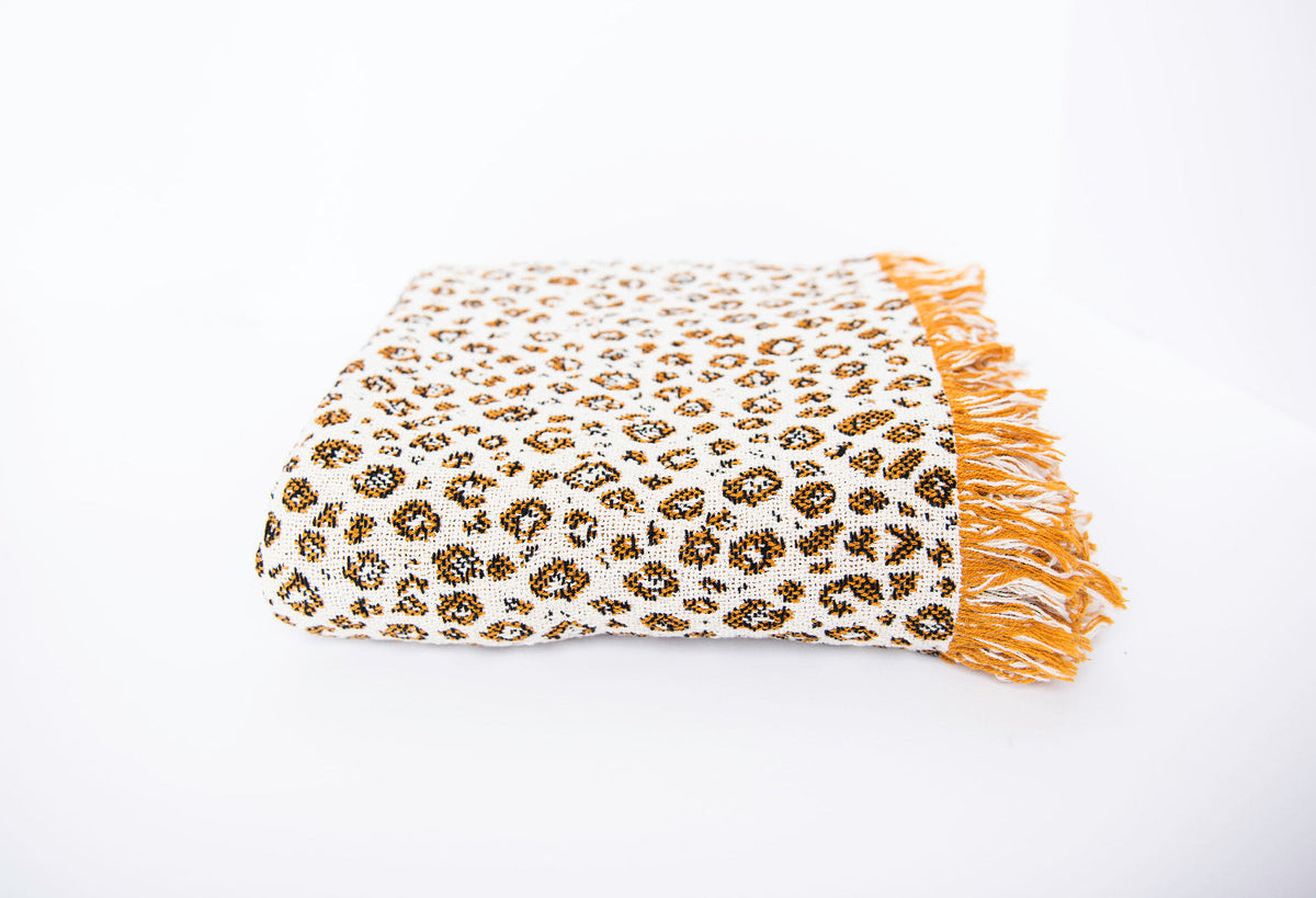 Side view of folded Zola leopard-print woven throw with golden fringe