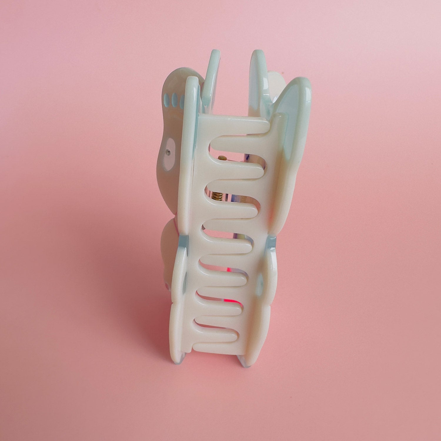 A maneki-neko white cat hair claw with a pink heart from Centinelle. Handmade on cellulose acetate, with splice technique, exquisite miniature details and crystals, that are tied directly to its value and make them unique and special. 