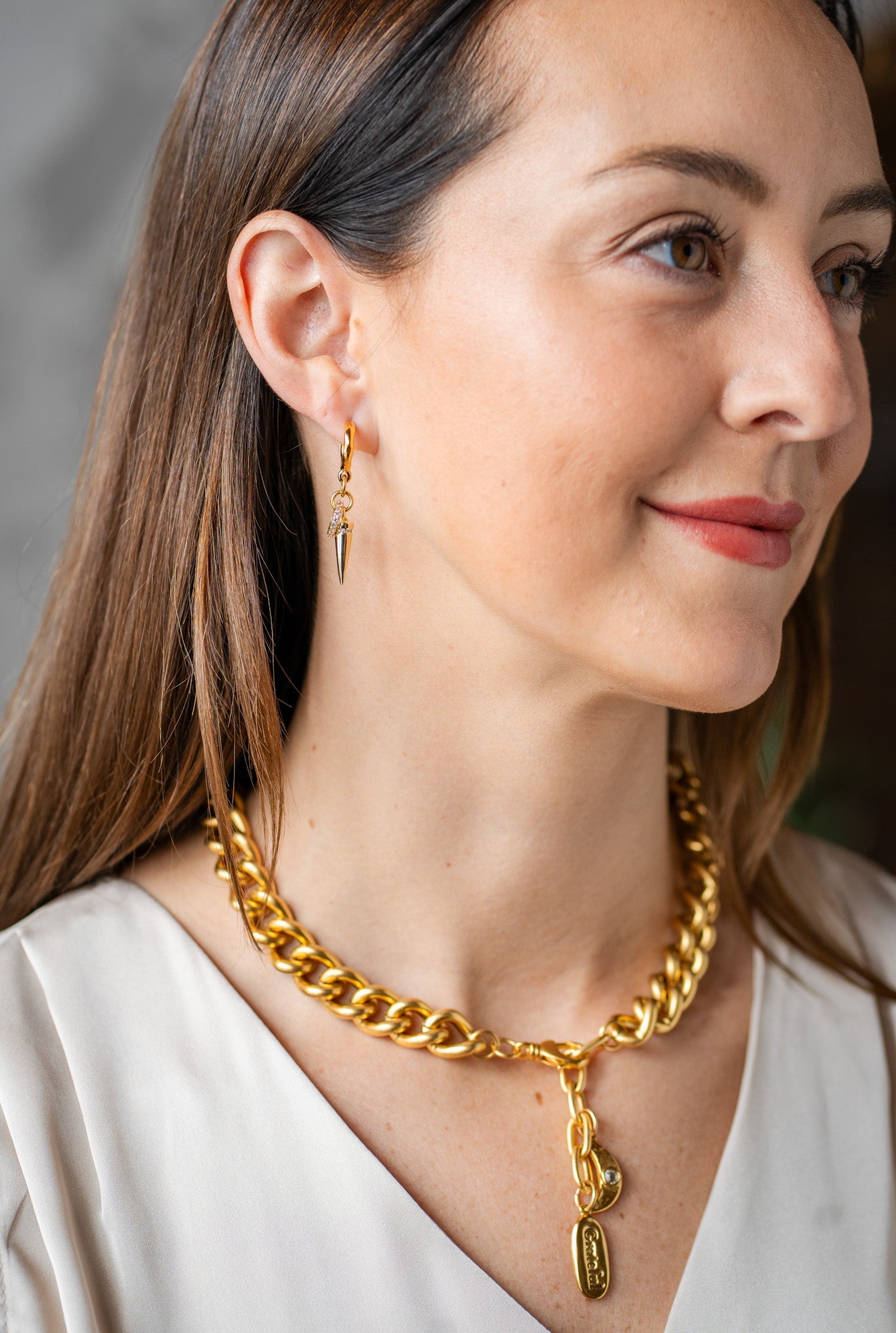 Chunky gold necklace with a large ridged heart charm and “grateful” tag, worn three ways