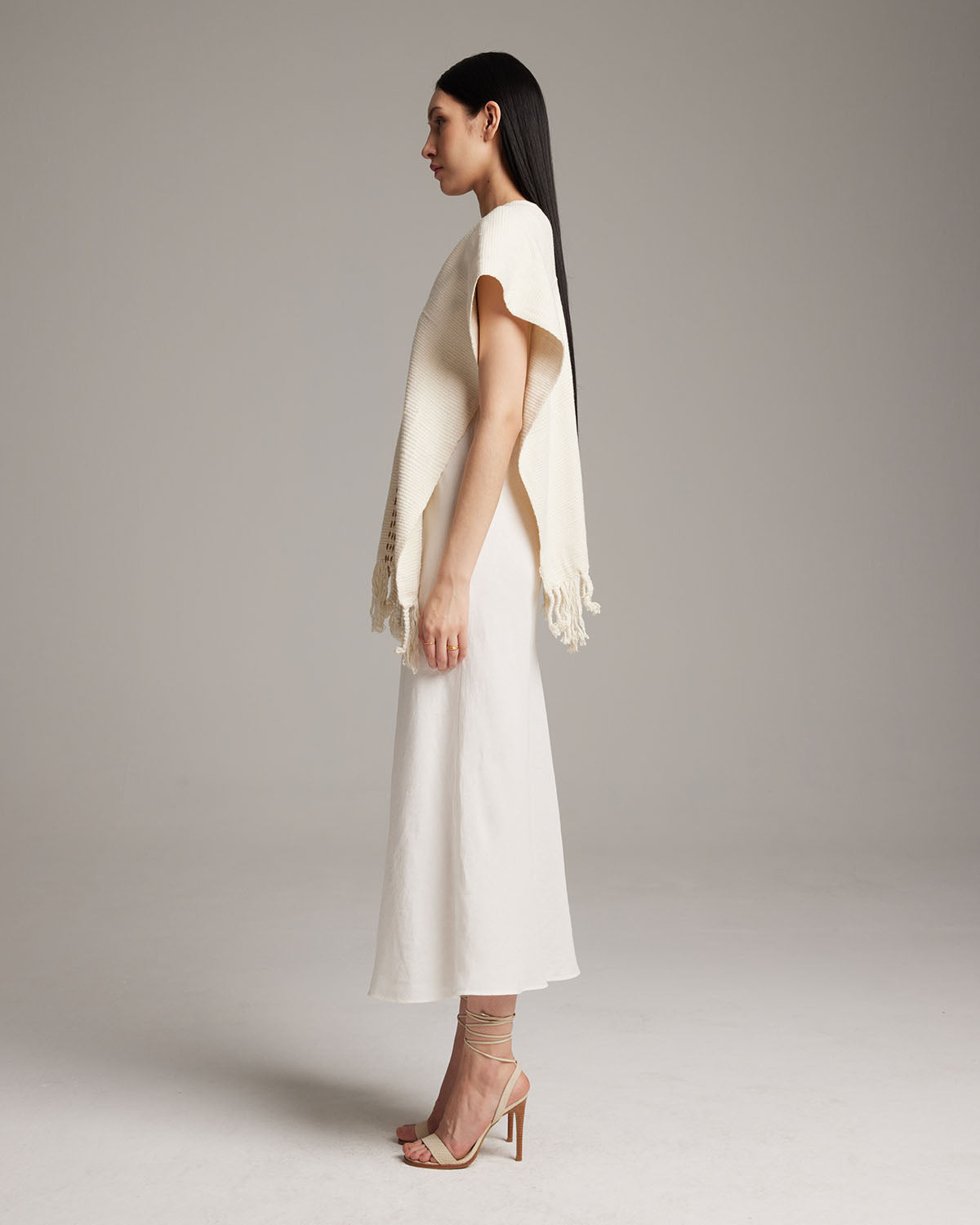 Model wearing a hand-loomed ivory Copper Threads Manta with fringe detail