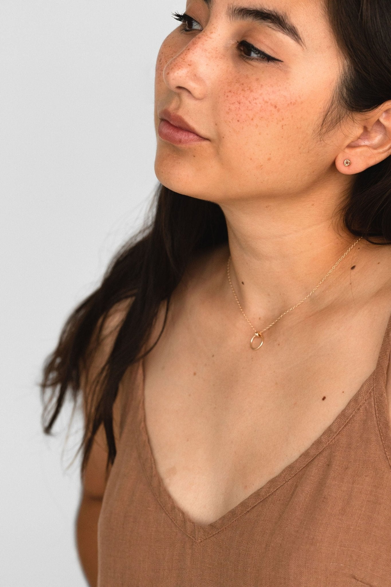 Model wearing Petite Knot Studs in 14k gold fill, highlighting their delicate craftsmanship, Love Knot Earrings • Dainty Stud Earrings • Minimalist Knot Earrings in Gold and Sterling Silver • Gift for Her • Bridesmaid Gifts, Sheena Marshall Jewelry Denver Colorado