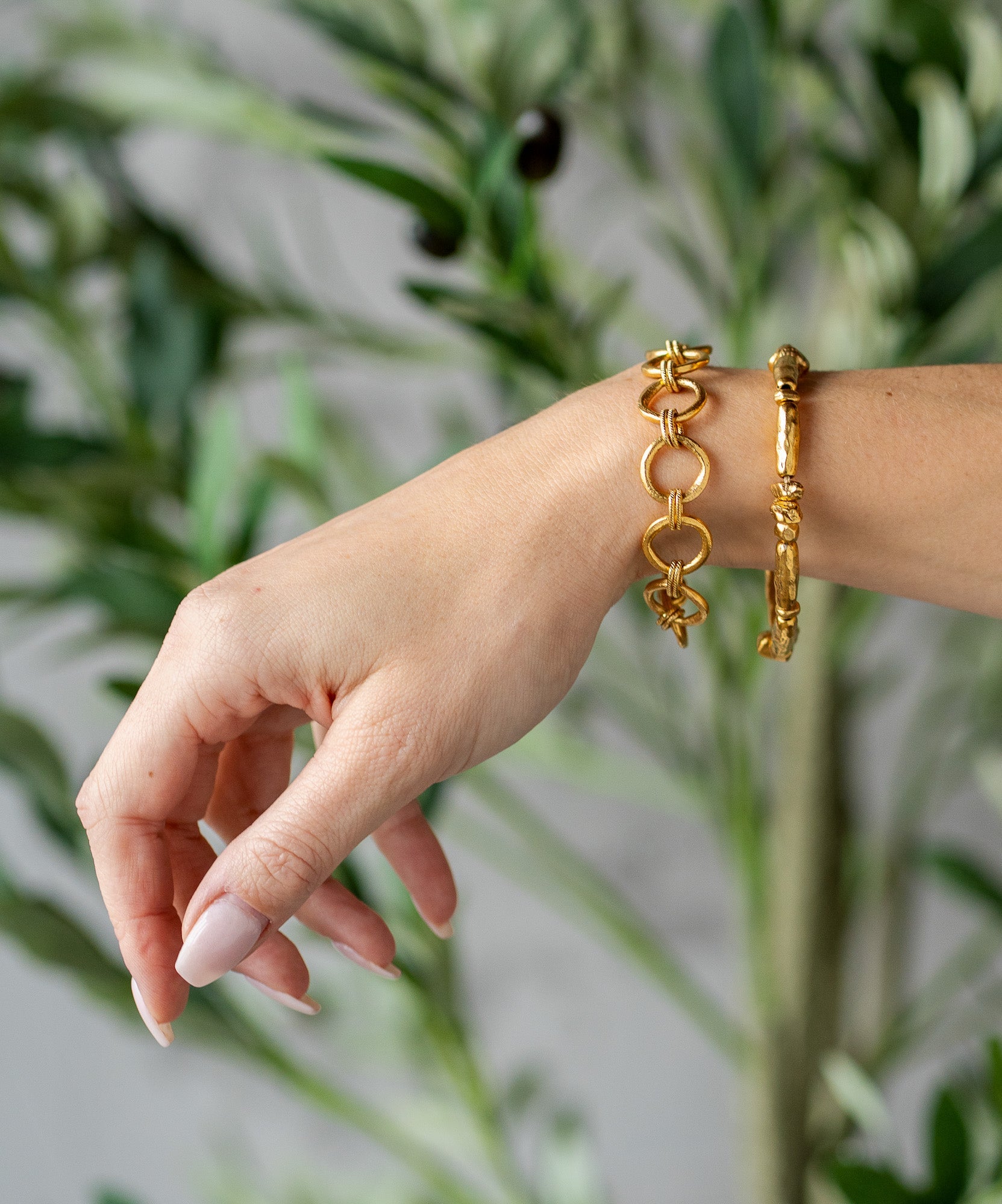 Gold-toned bracelet with sculptural organic beads and a toggle clasp, styled in a circular shape.