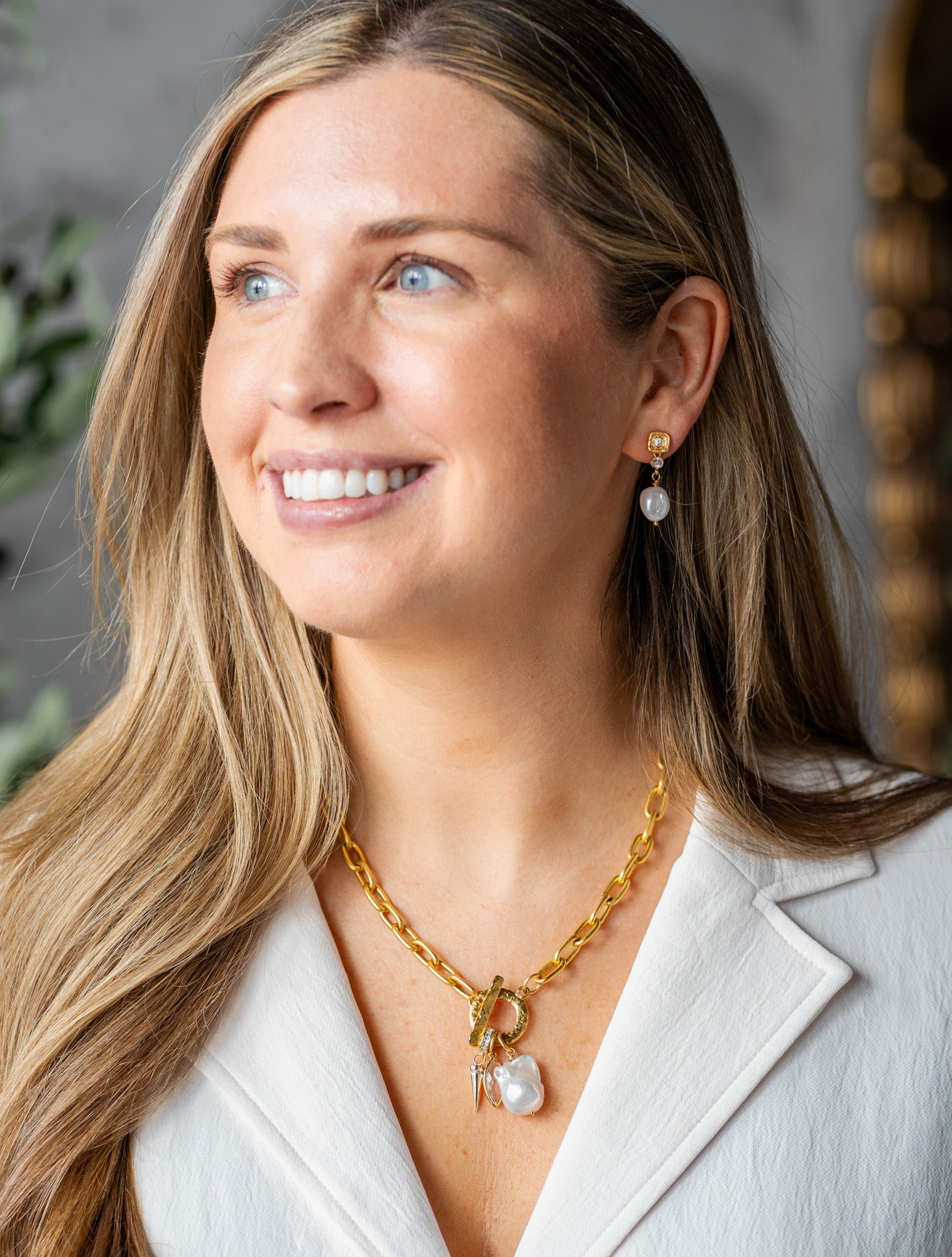 Gold chain necklace with toggle clasp, featuring a baroque pearl, marquise-cut crystal, and gold spike charm