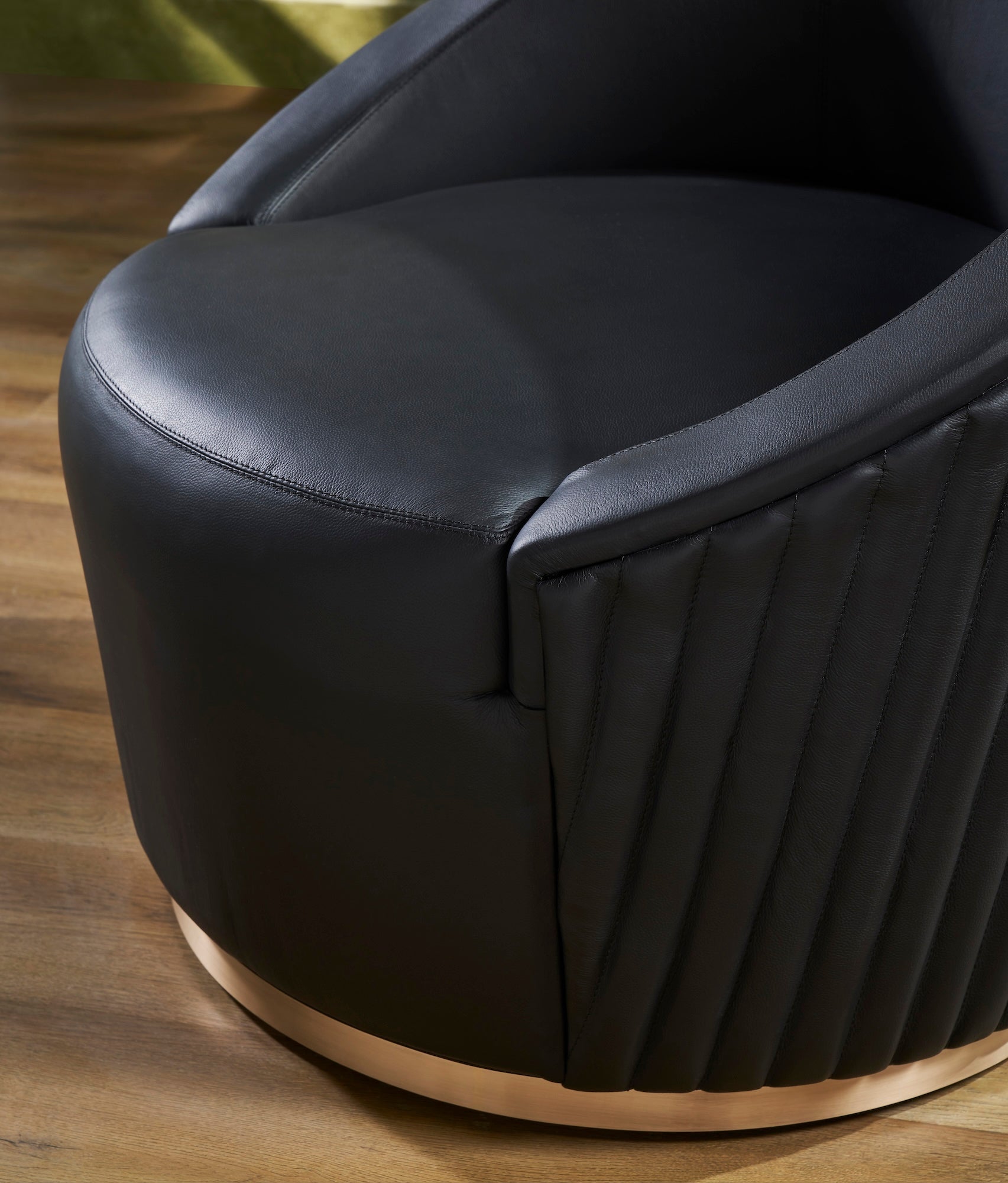 FN-5207-353529_5|Close-up of luxurious black leather swivel armchair, highlighting plush seating and elegant vertical ribbed design, premium furniture.