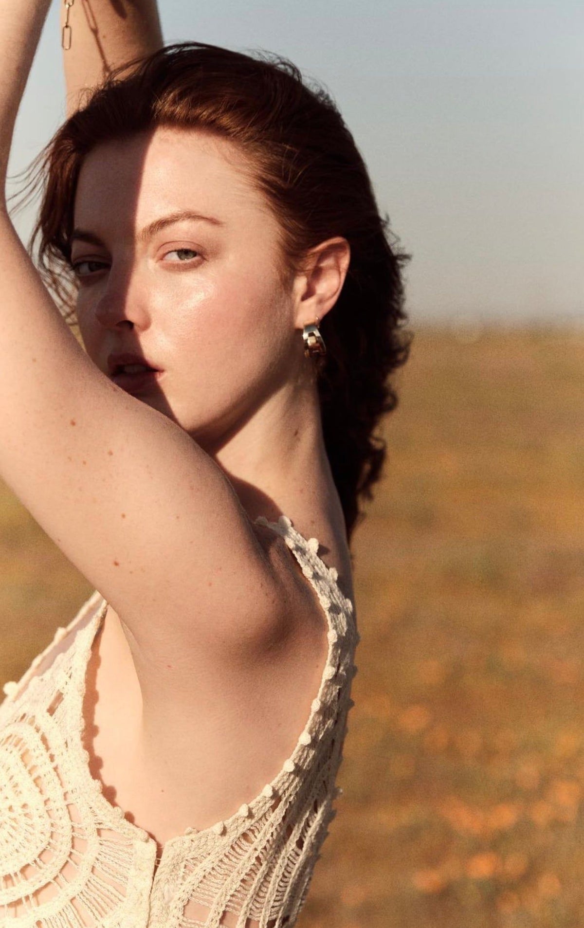 Woman in a lace dress wearing Theo Cut-Out Tapered Hoops jewelry