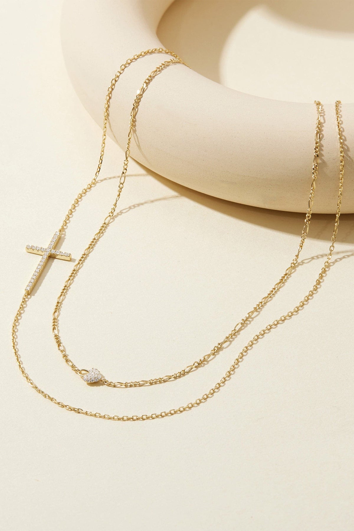 Gold-toned layered necklace with pave-set rhinestone cross and heart charm for women
