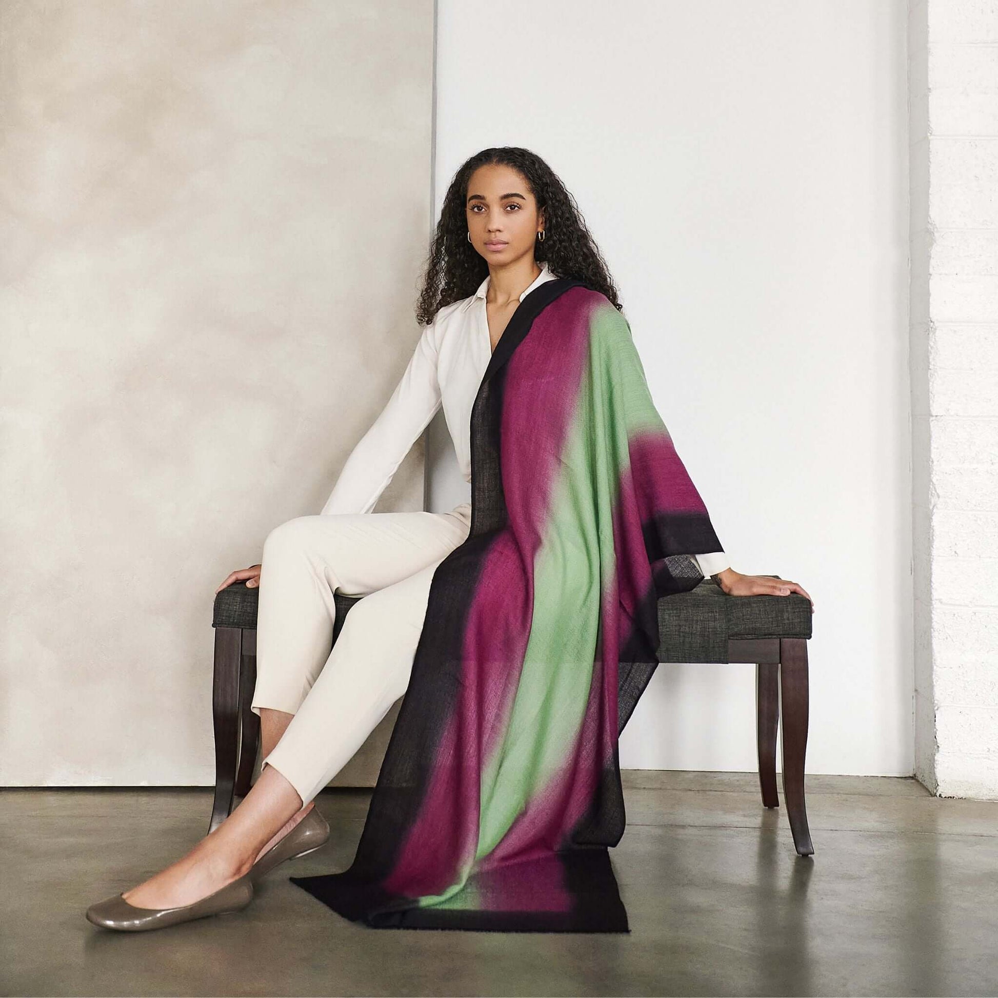 Iris Courtyard Green Purple Hand Woven Cashmere Merino Scarf draped elegantly on a model in a stylish setting.