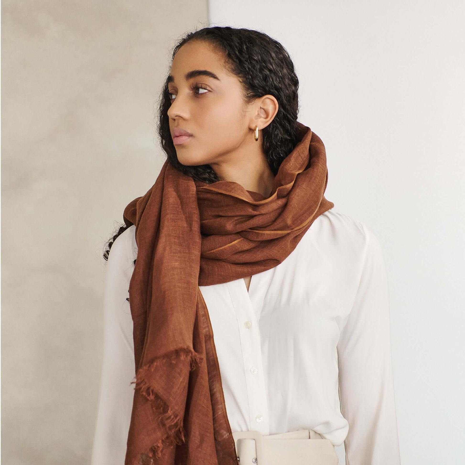 Coco Brown Hand Woven Linen Silk Blend Scarf elegantly styled with a white blouse, showcasing its rich earthy tones.