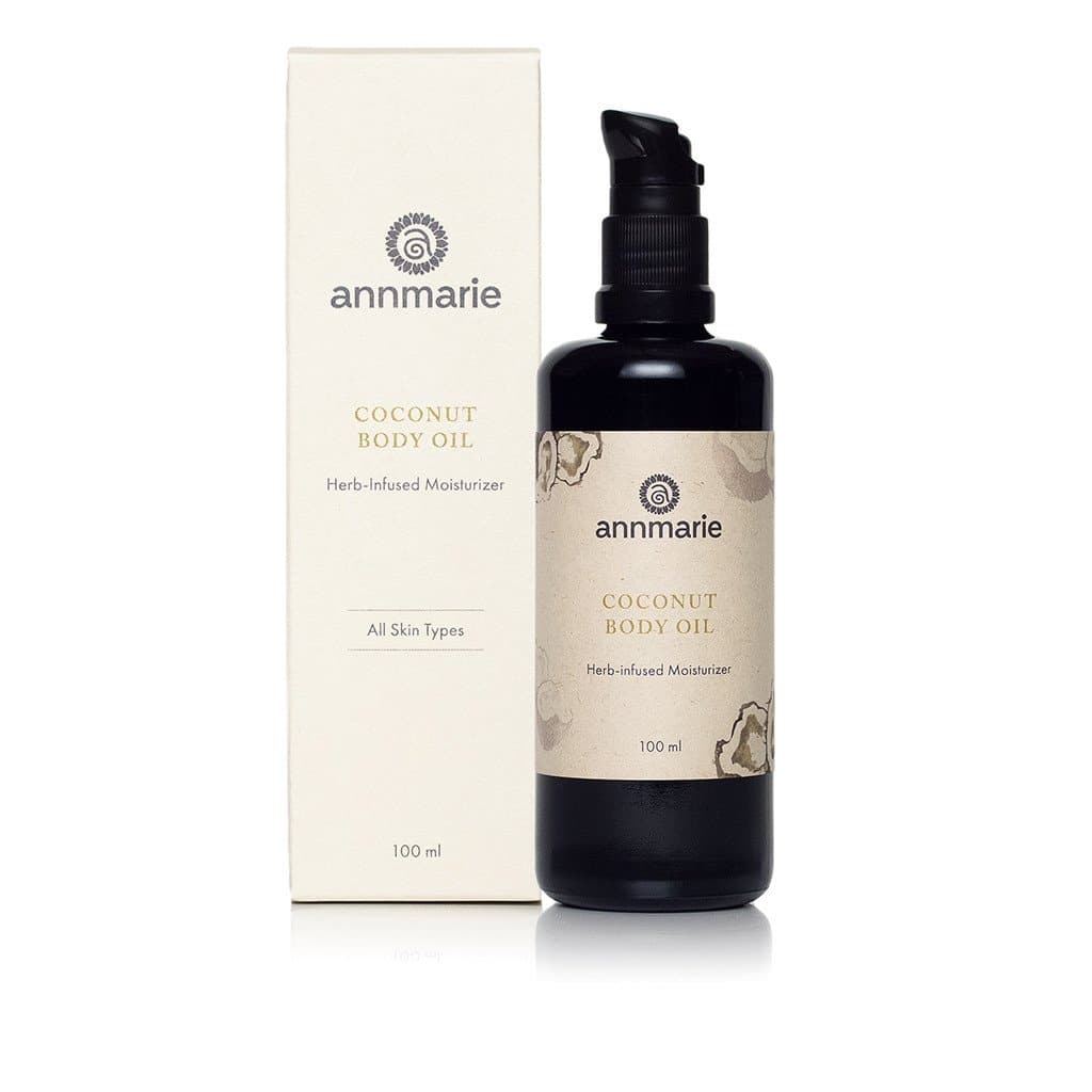 Coconut Body Oil herb-infused moisturizer in dark glass pump bottle with product box, 100 ml.