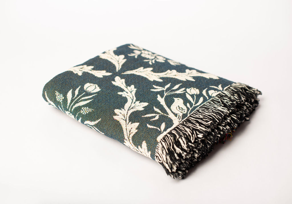 Folded Isobel Thistle botanical woven cotton throw blanket shown from the side