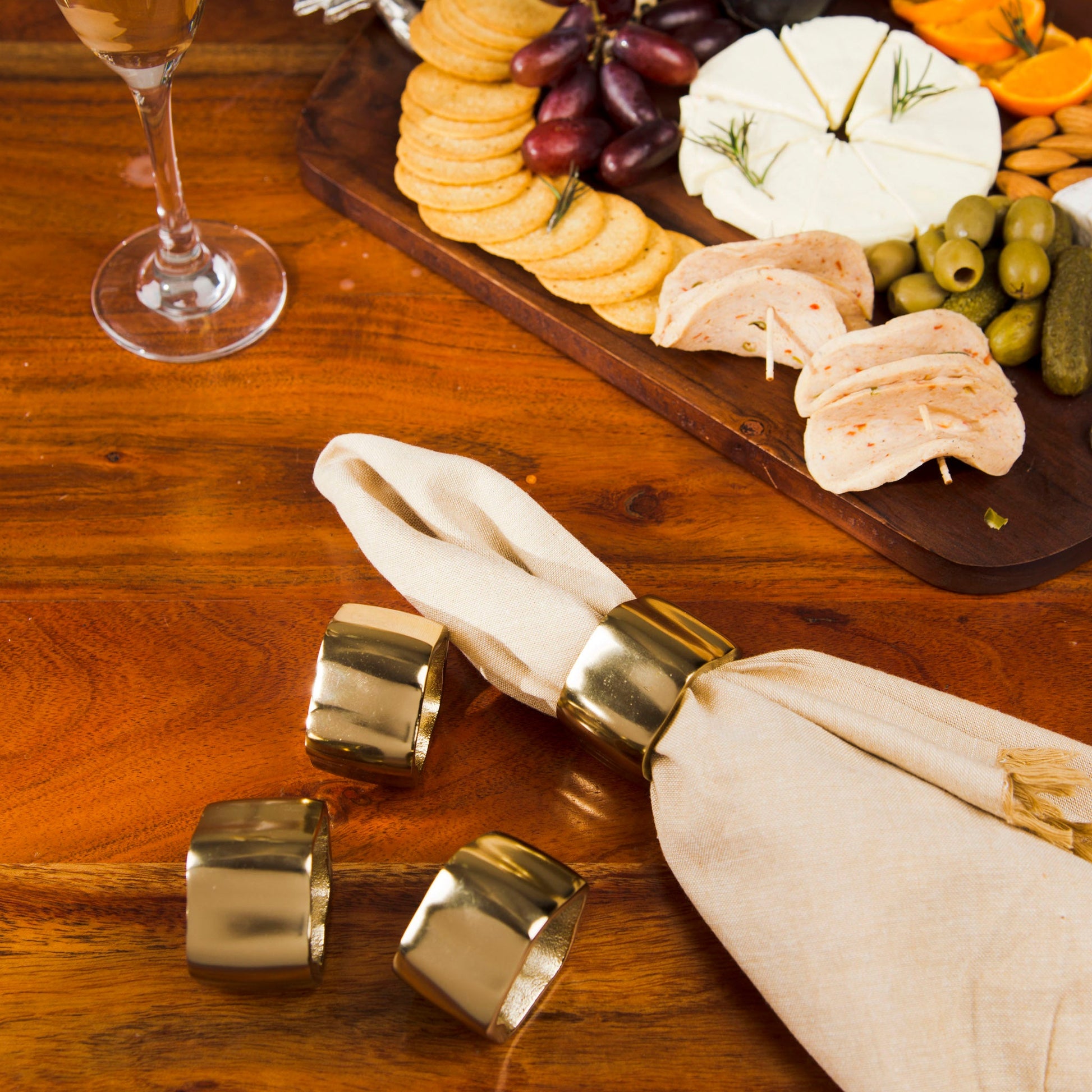 Hand-finished gold metal napkin rings featuring a heavy, textured organic design for a luxury table setting.