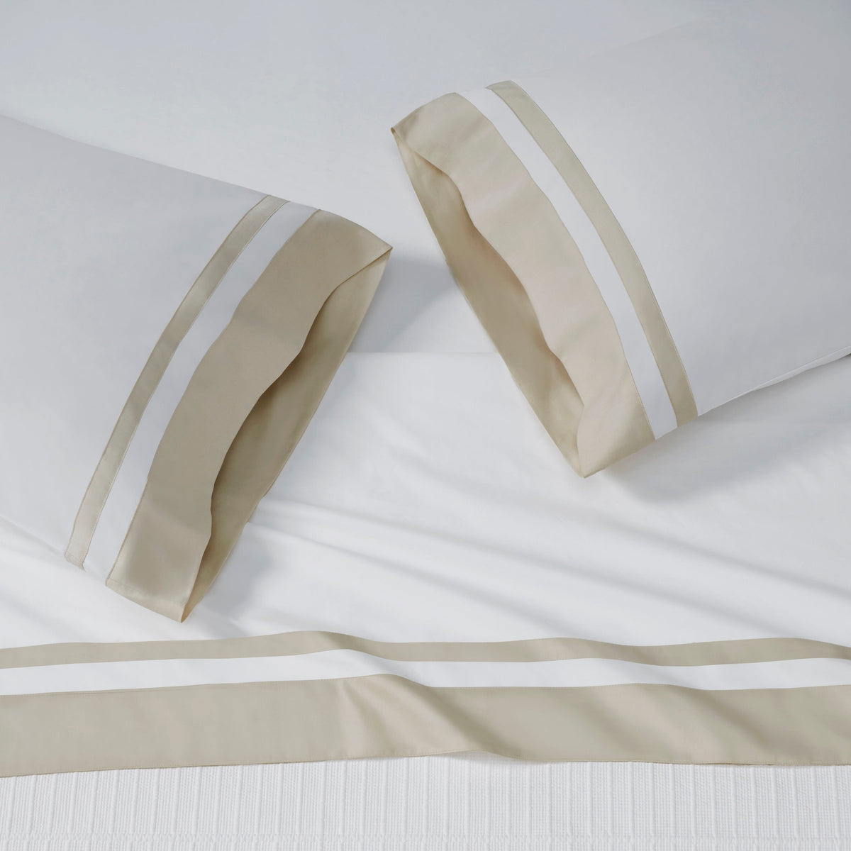 AKP-542-2040_4|Stack of five folded 100% cotton sateen sheet sets, each with a distinct contrasting border visible on the hems.