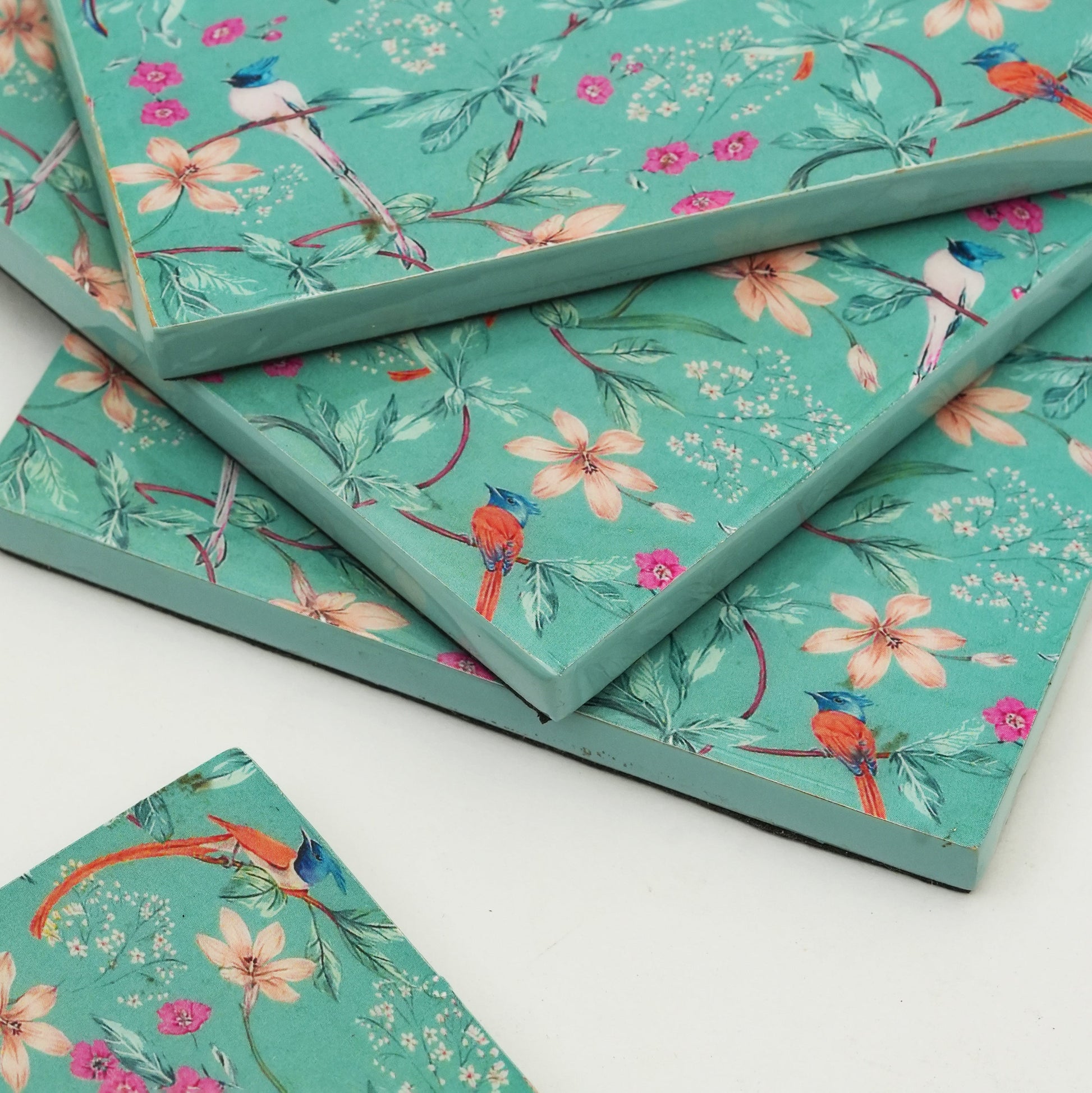 Stack of notebooks with floral and bird design on a white background