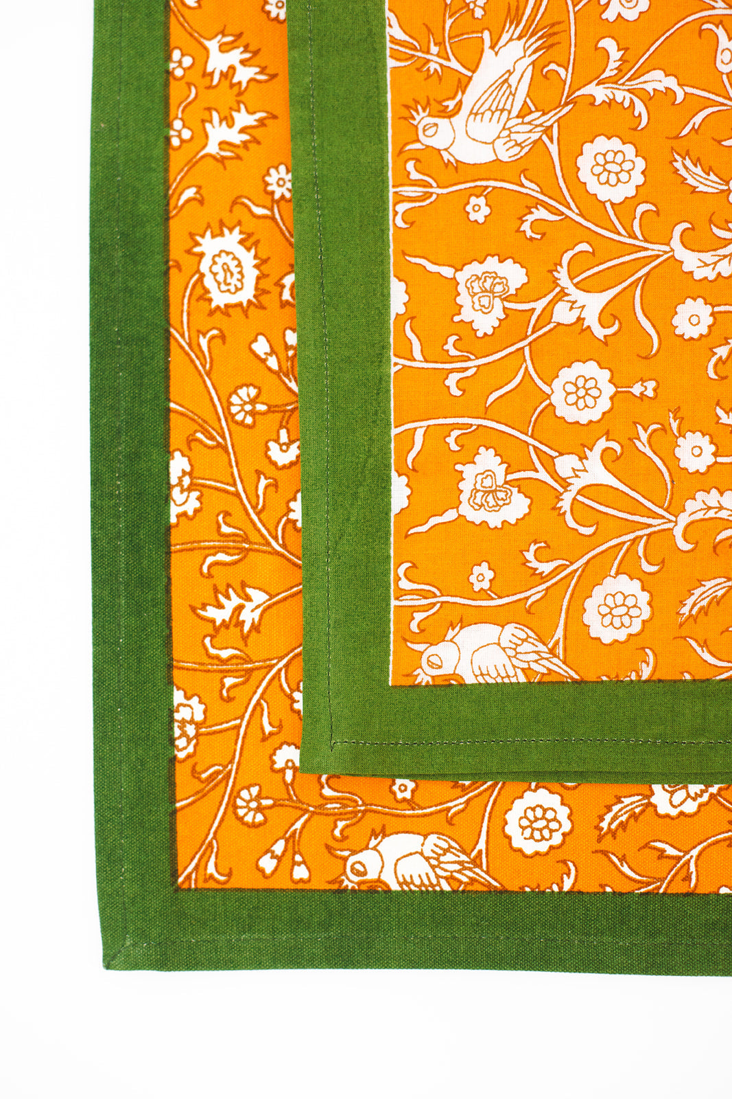 Layered orange blockprint placemats with green borders from Inner Child