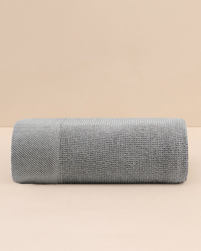Gray textured throw blanket on a beige background