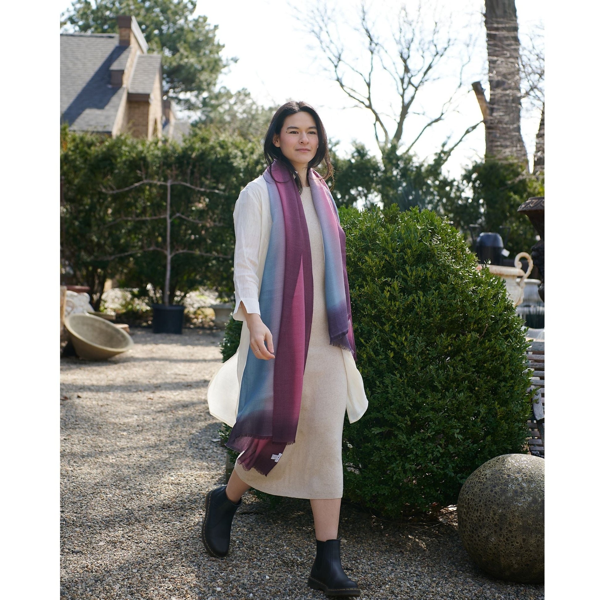Iris Haze Blue Pink Cashmere Merino Handloom Scarf worn by a model in a garden setting.