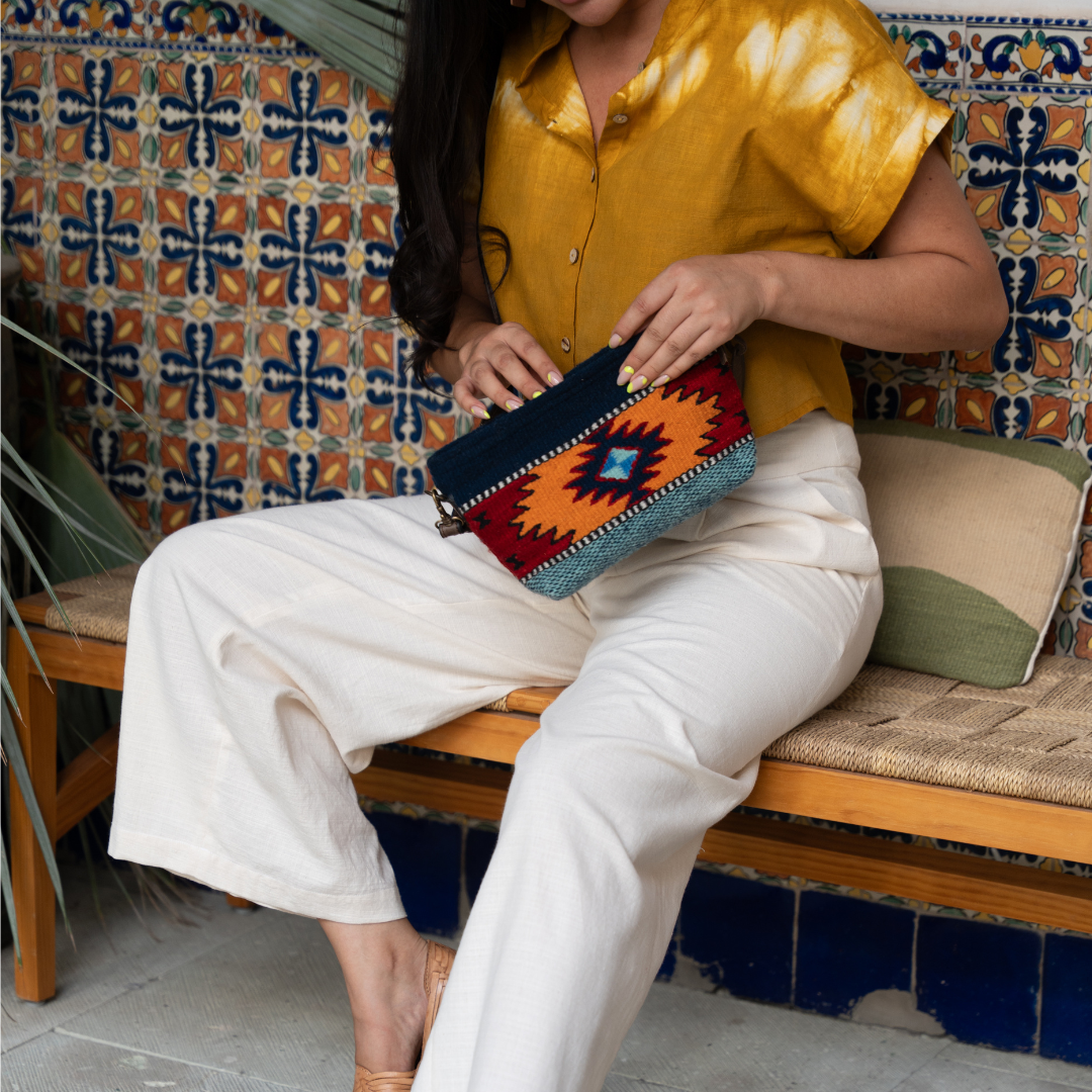 Handwoven convertible clutch with Zapotec pattern in bold colors; can be used as a pouch, wristlet, or crossbody with included leather straps and internal pocket.