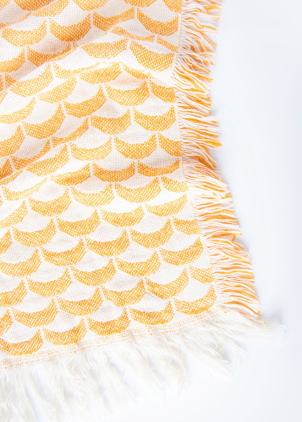 Close-up of Sadie golden yellow and cream scallop woven cotton throw with fringe