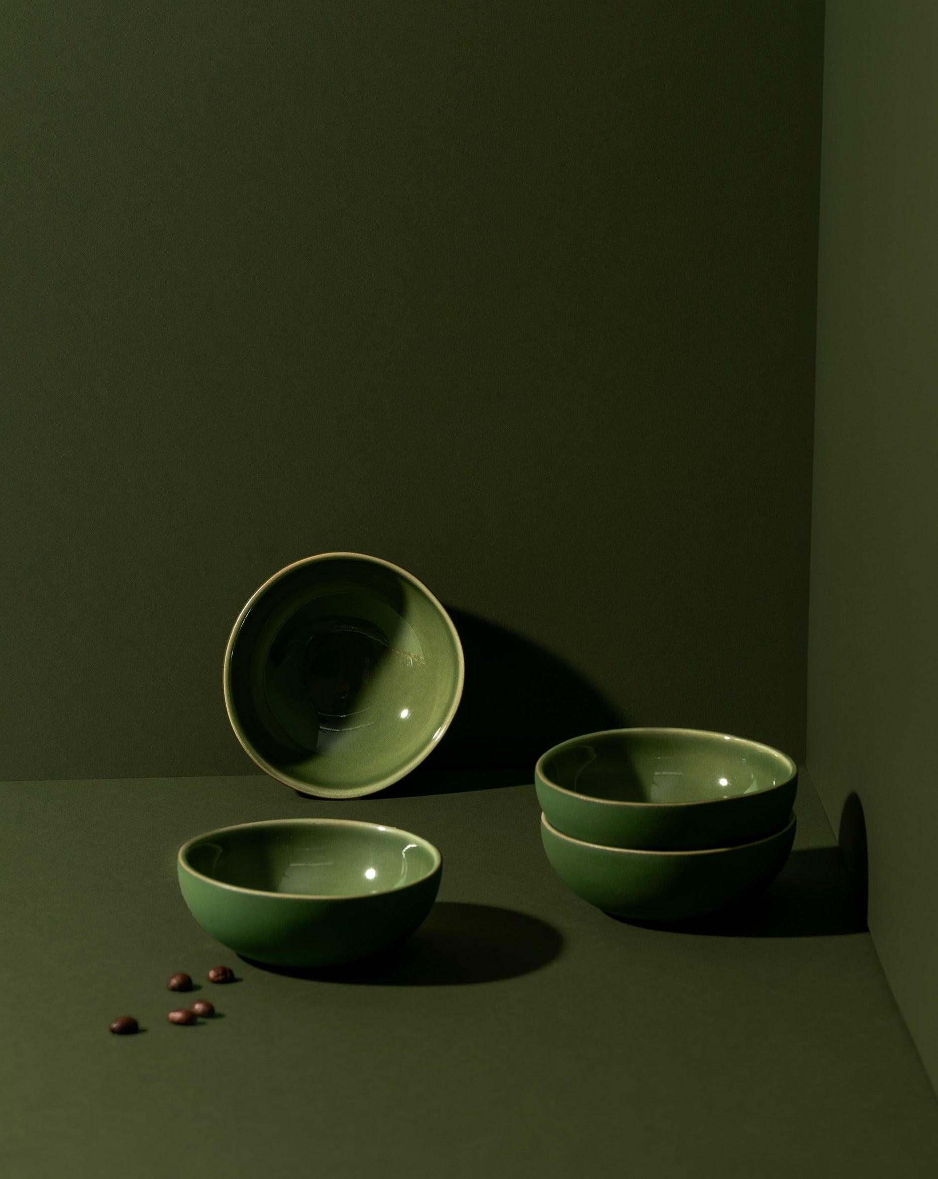 Three round stoneware condiment bowls in a matte finish, with one bowl containing some condiments, placed on a neutral background.