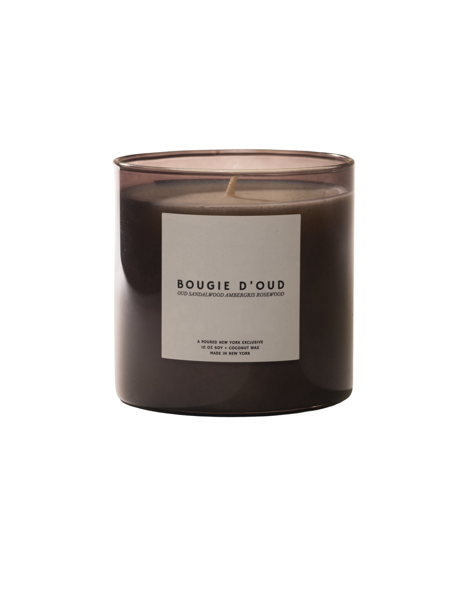 Candle labeled 'Bougie D'Oud' next to a black box with 'POURED' branding and a crown decal on a light background