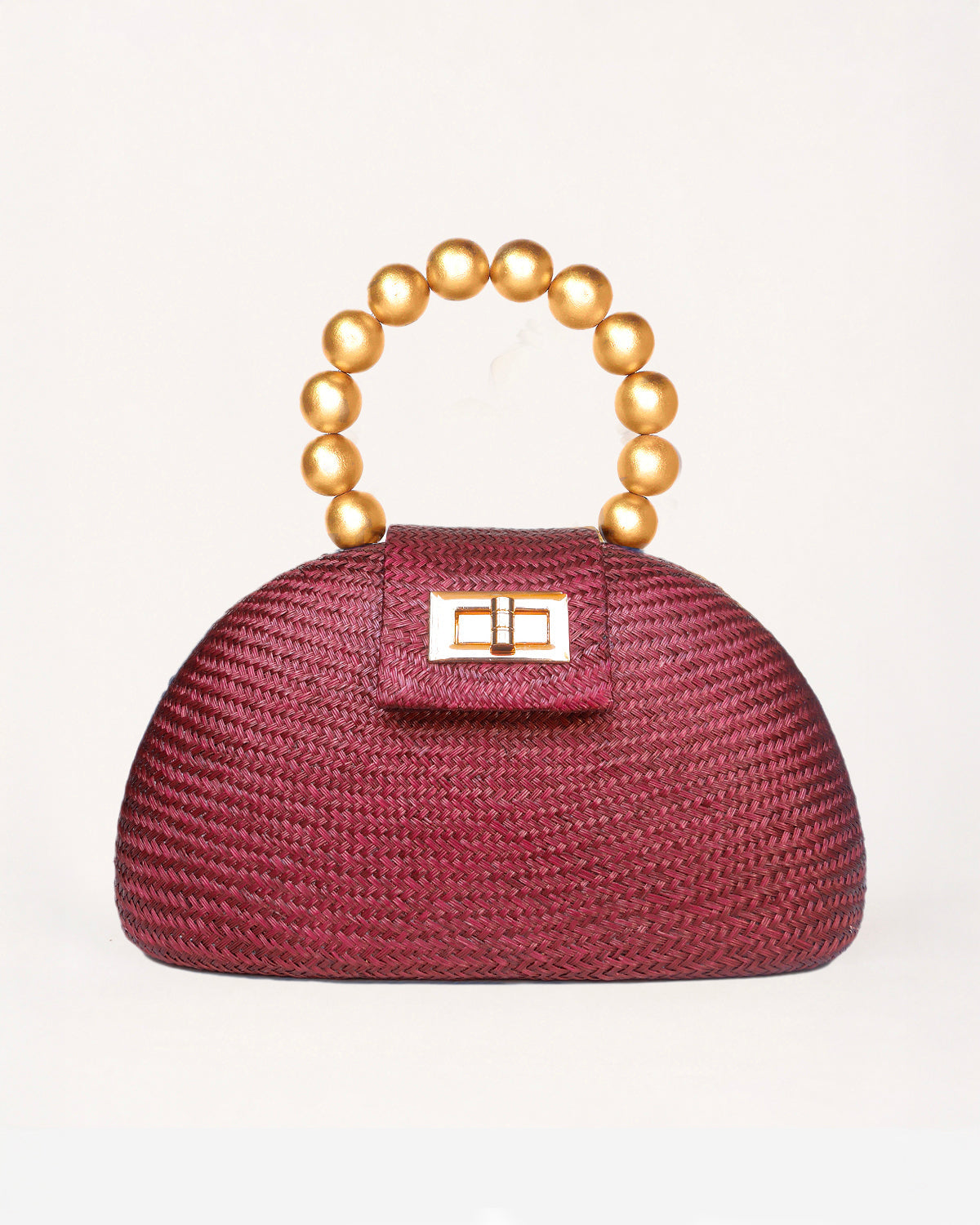 The Orla maroon woven straw half-moon bag with gold beaded handle, front view