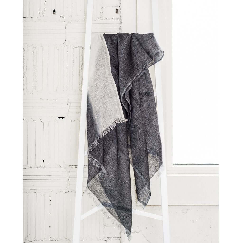 Granite Black White Ombre Linen Silk Handloom Scarf displayed elegantly on a white ladder against a textured wall.