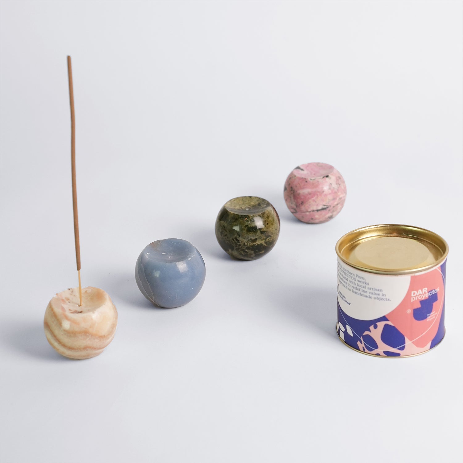 Collection of gemstone sphere incense holders in Rhodonite, Serpentine, Angelite, and Onyx showcasing their natural colors.