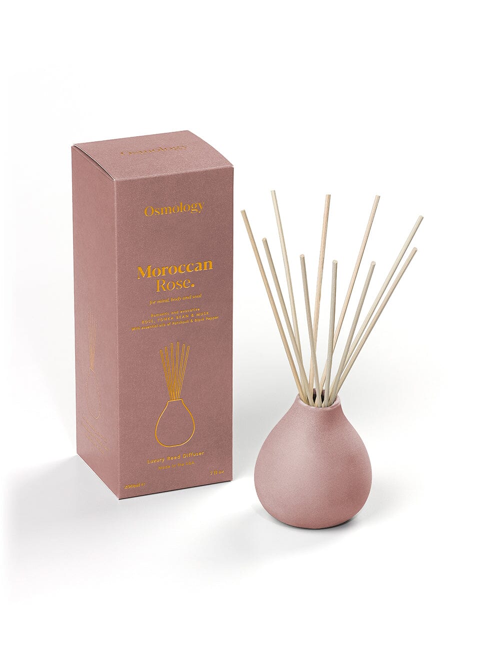 Osmology Moroccan Rose reed diffuser with reeds with product packaging on cream background