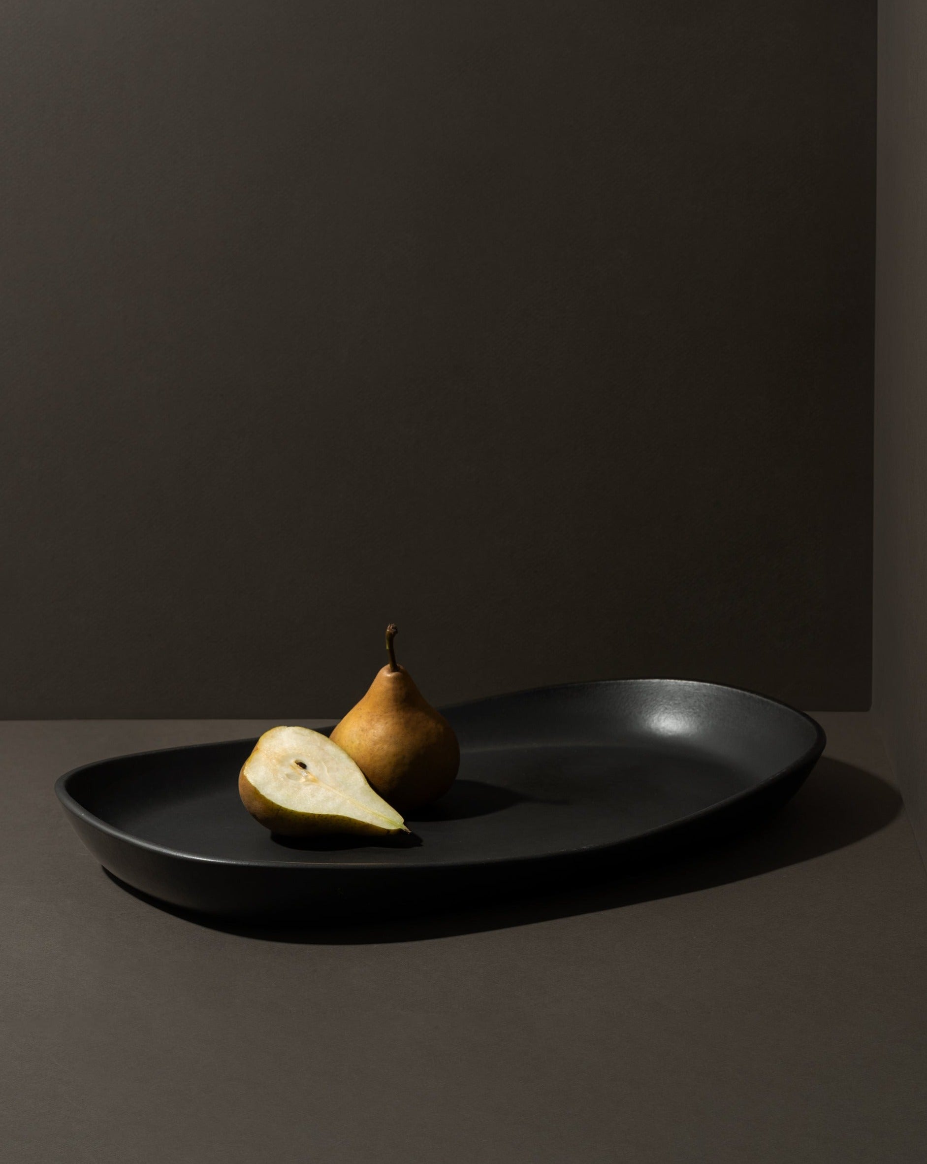 Mini stoneware serving platter with a selection of pastries and blackberries on a kitchen countertop.