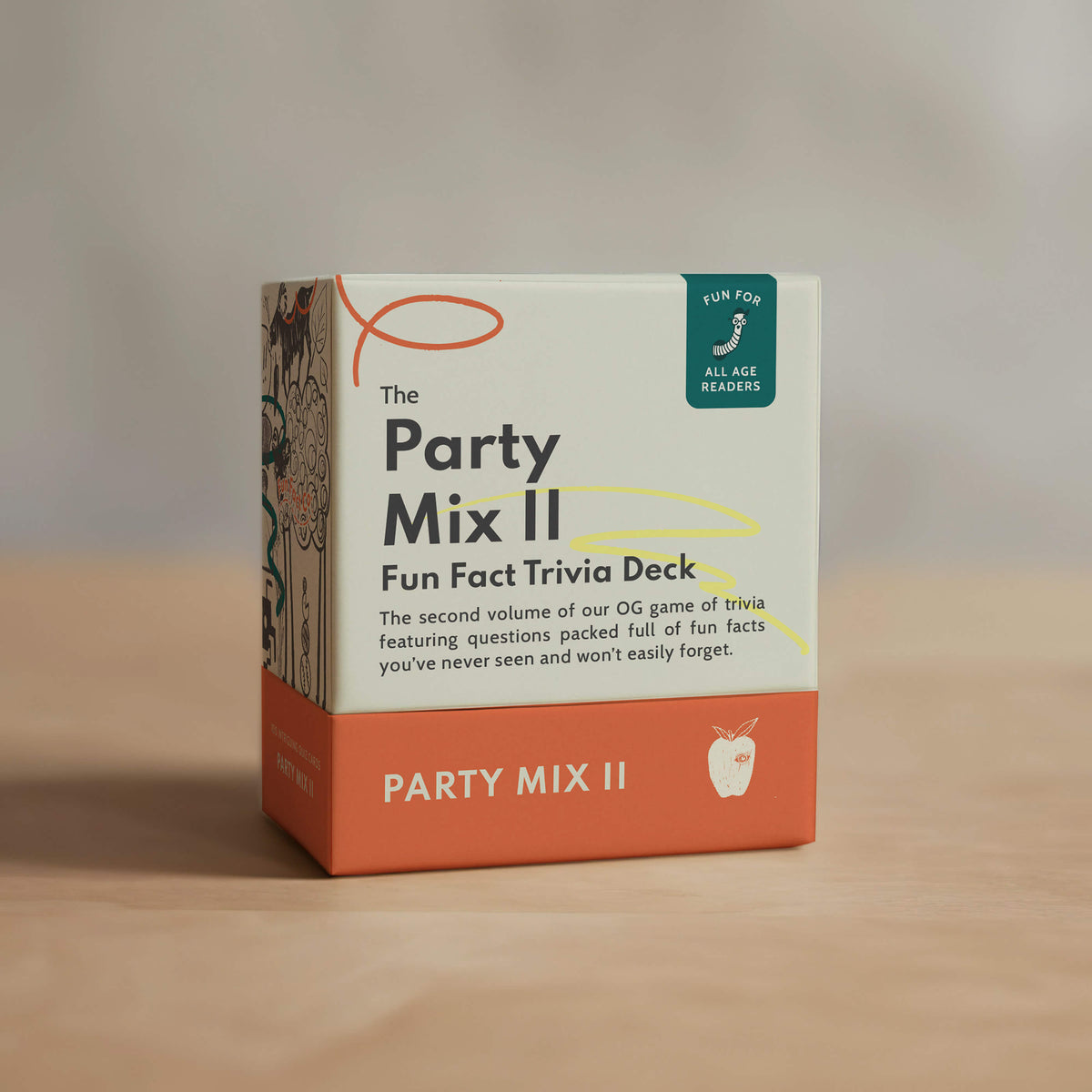 Box of 'The Party Mix II' Fun Fact Trivia Deck on a wooden surface with a neutral background