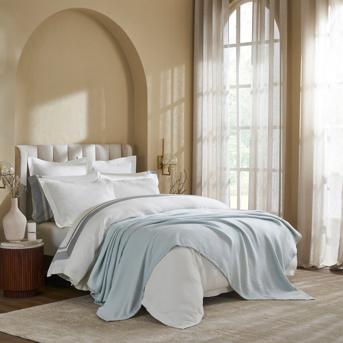 BL-863-11096_3|Luxurious light blue textured muslin blanket draped gracefully over a crisp white duvet in a modern, elegant bedroom setting.