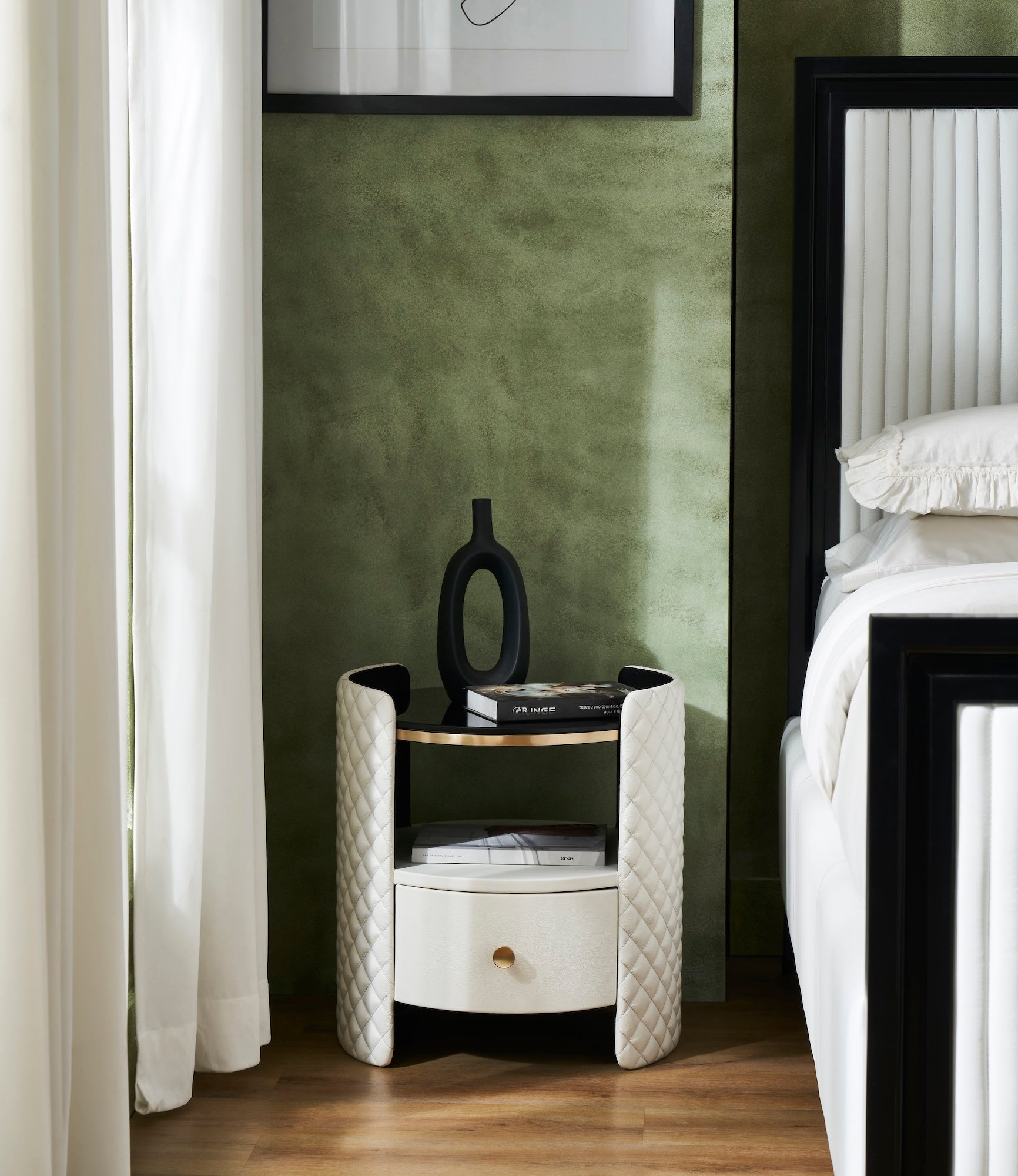 FN-5214-202022_5|White curved quilted leather nightstand with a black top and gold trim. Features one drawer and a single open shelf.