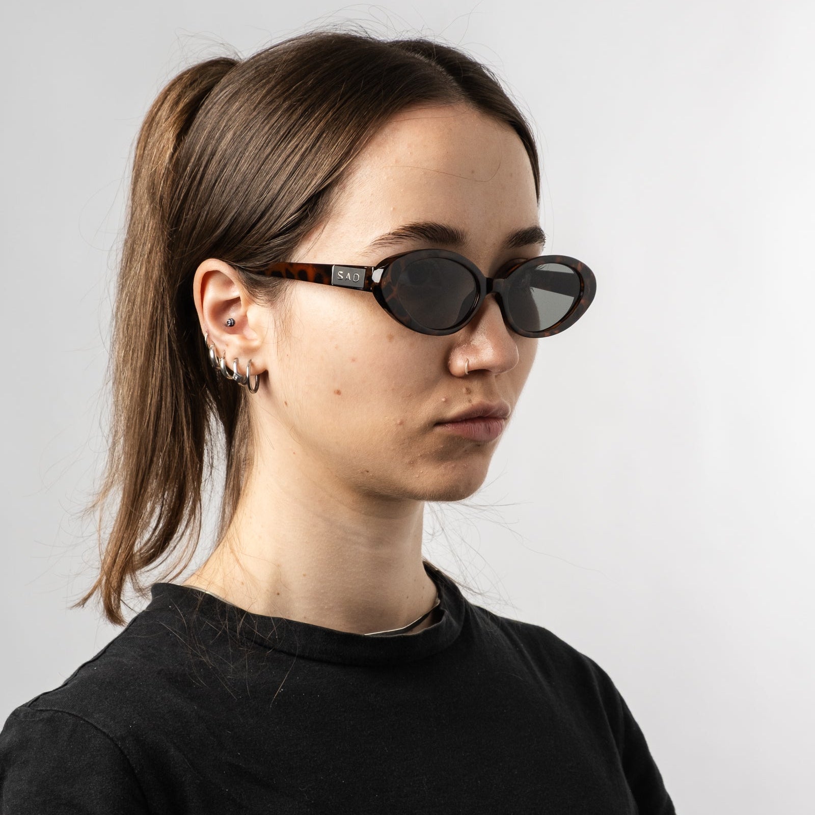Female wearing Sad Eyewear Bloom oval sunglasses in tortoise with UV protection lenses