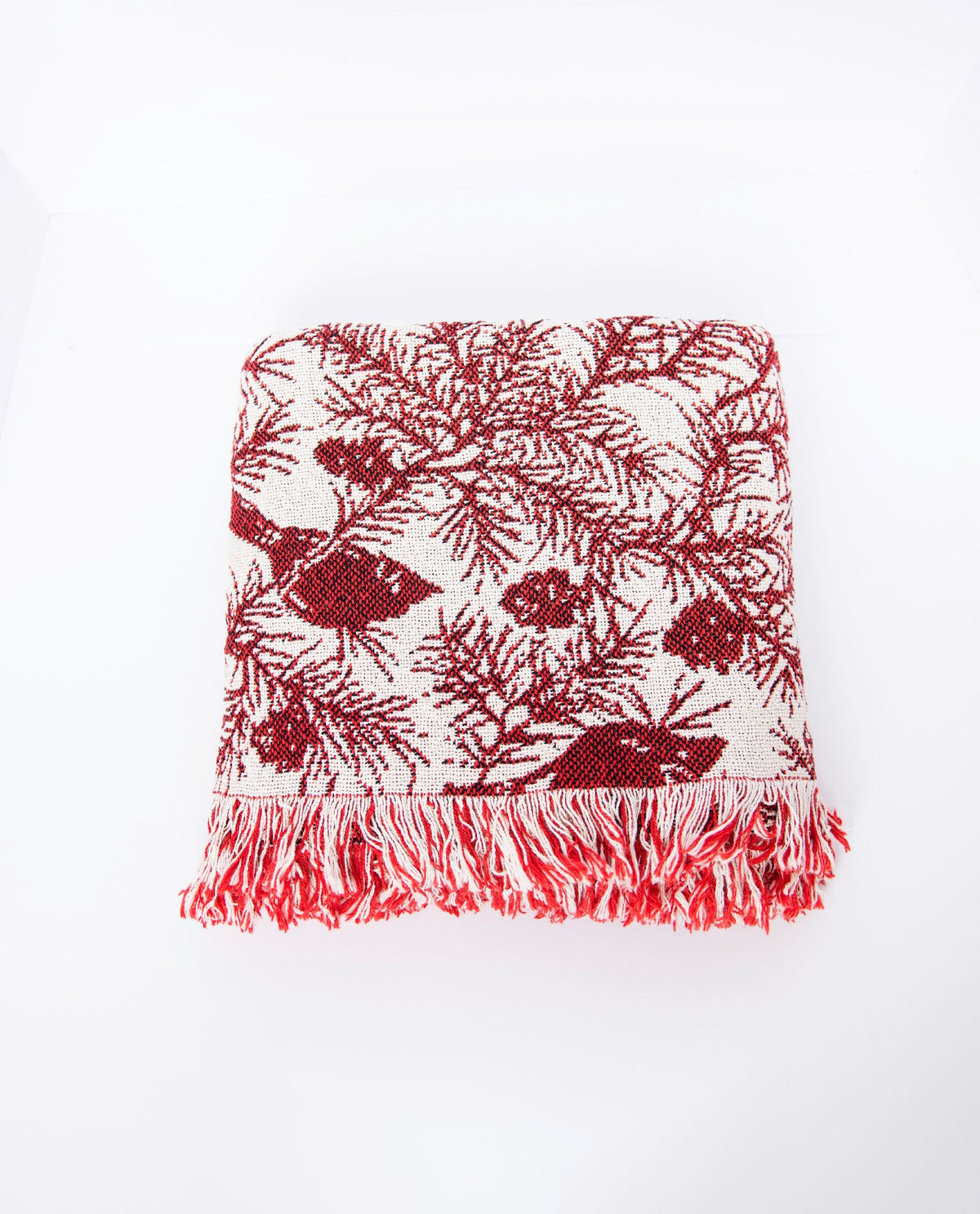 Front view of folded Cherie Cranberry cardinal and pine Christmas throw on a white background
