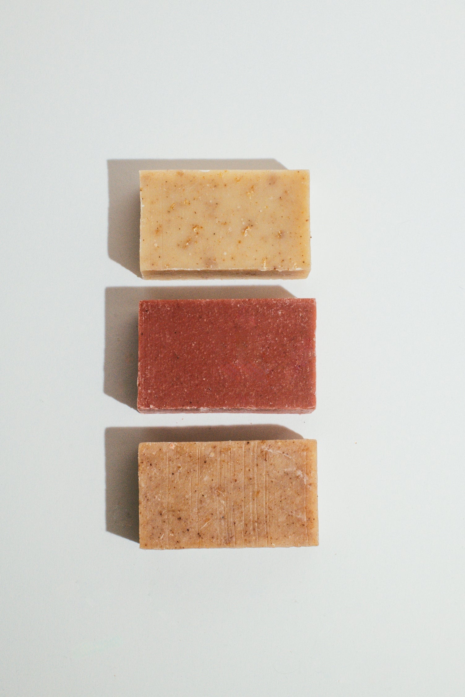 Wenjulan Whole Body Care Cleansing Bar Trio bundle gift pack featuring Wenjulan Unscented Cleansing Soap with Colloidal Oatmeal bar, Wenjulan Sensitive Skin Cleansing Soap with Kaolin Clay bar, Wenjulan Southwest Cedar Cleansing Soap bar on a light gray background