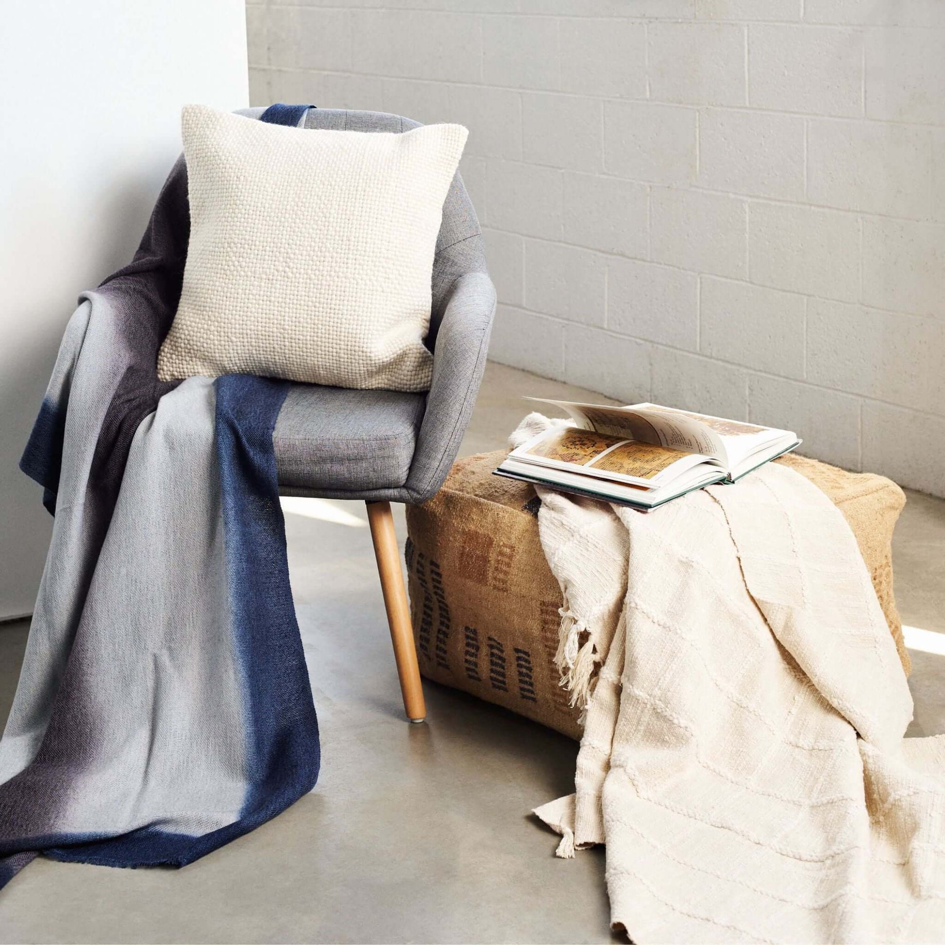 Sea Shell White Textured Checks Handloom Throw draped over a chair, showcasing its modern design and texture.