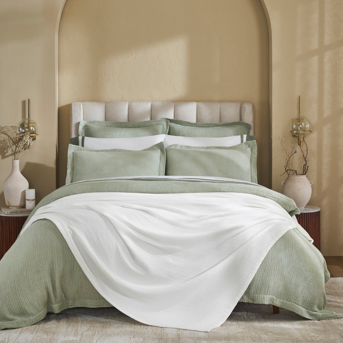 BL-861-9496_1|Soft white textured cotton blanket draped over a green duvet, adding a cozy and decorative layer to modern bedroom decor.