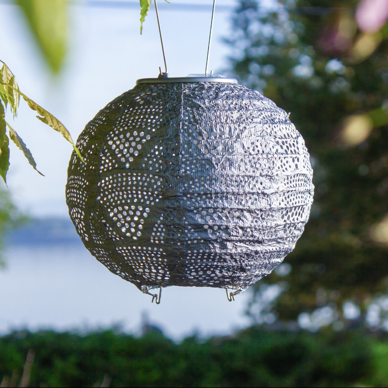 Soji Stella 8" Globe Tyvek Solar Lantern hanging in tree