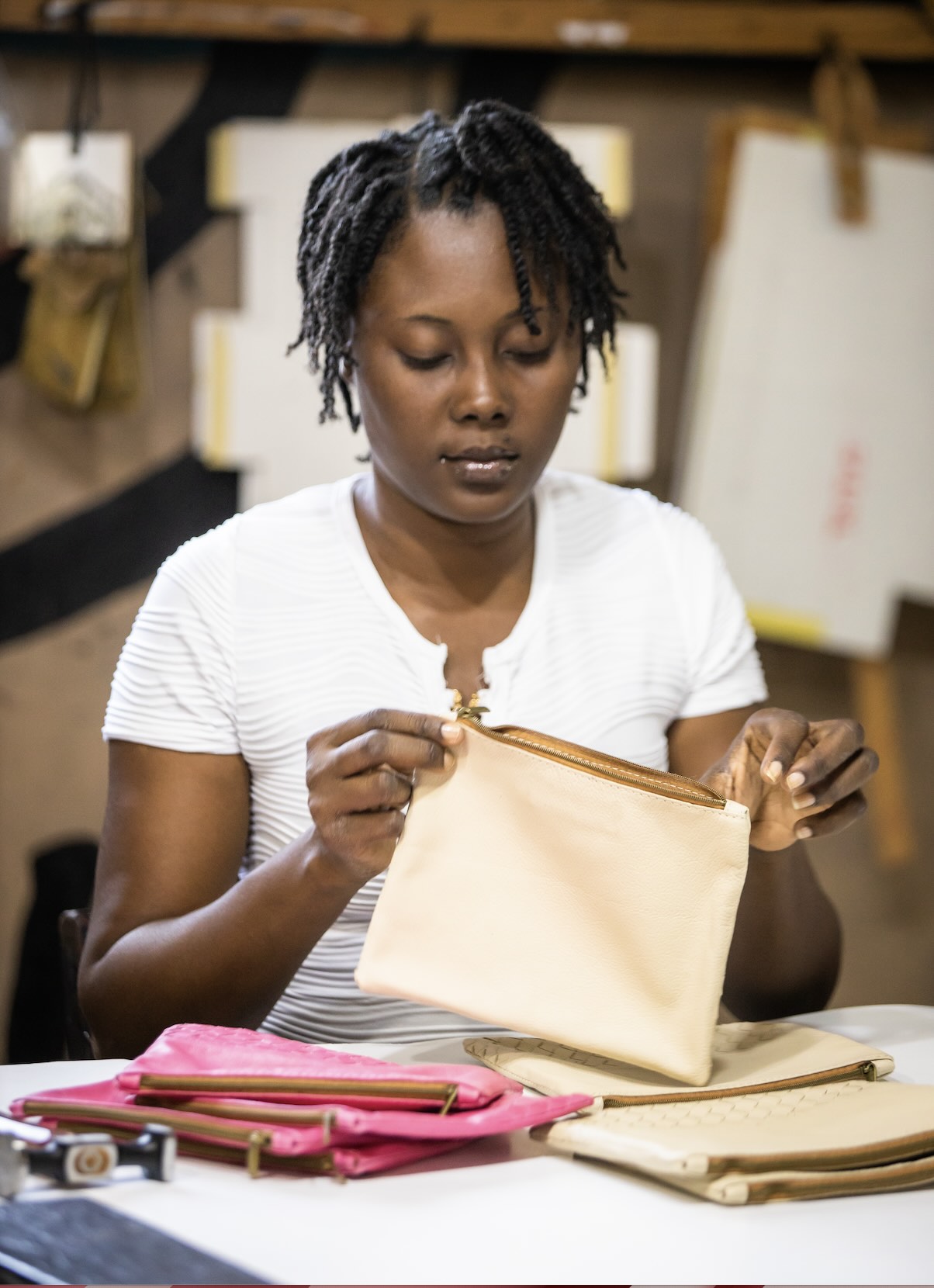 haitain artisan handcrafting the woven pouchs in our solar powered factory in haiti