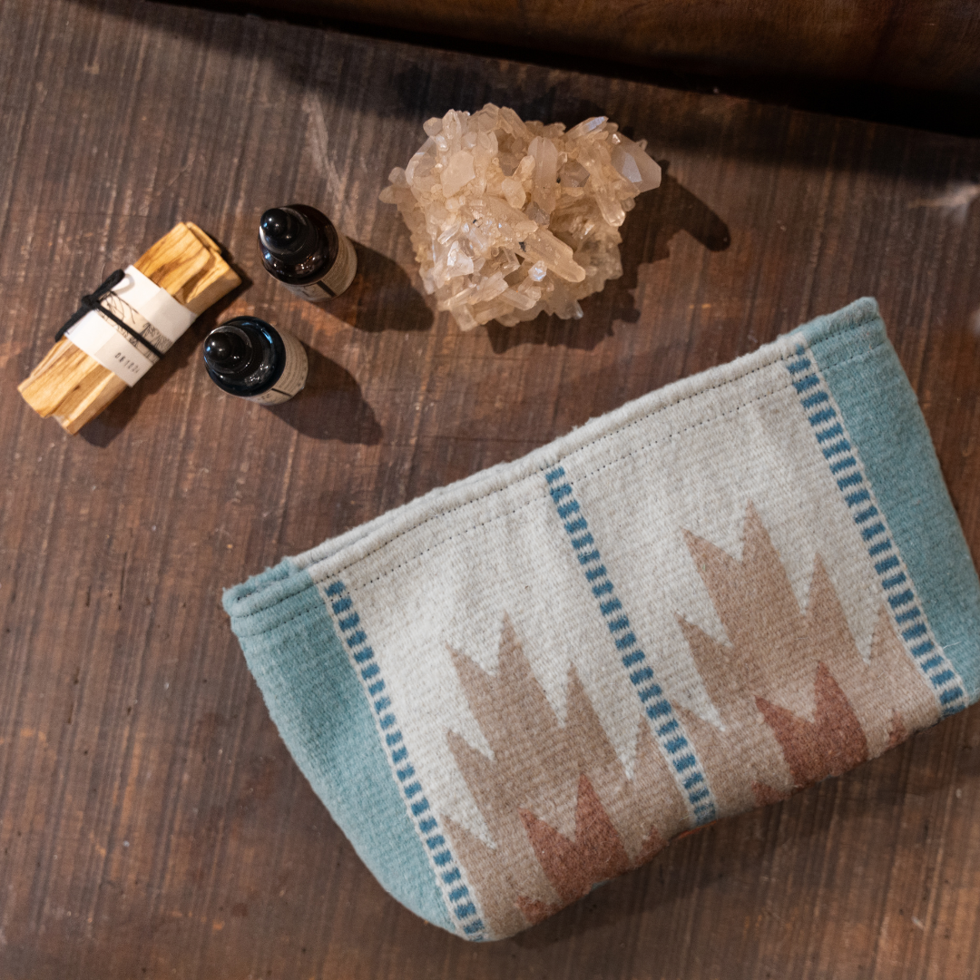 Handwoven pouch with abstract Zapotec lightning design in rose and blue tones, featuring internal pocket; ideal for use as a makeup bag, wallet, or tote organizer.