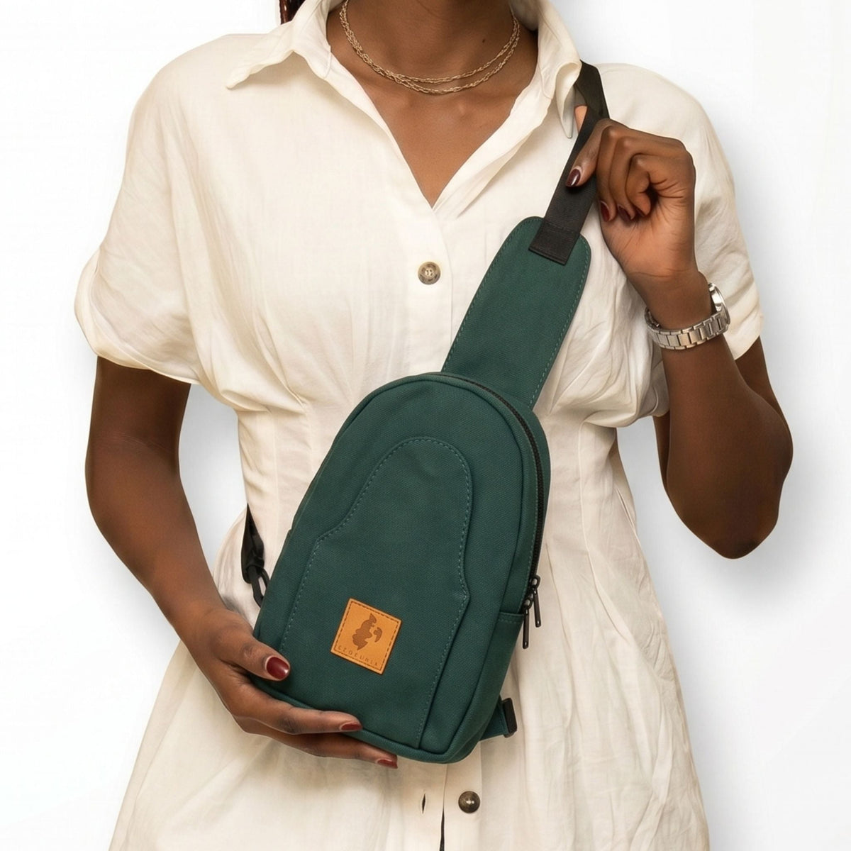 Buru canvas sling bag in forest green worn crossbody #color_forest-green