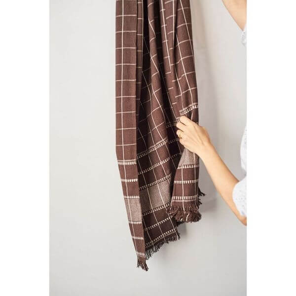 Treacle Checks Pattern Organic Cotton Handloom Throw draped and held, showcasing its heritage design and quality craftsmanship.