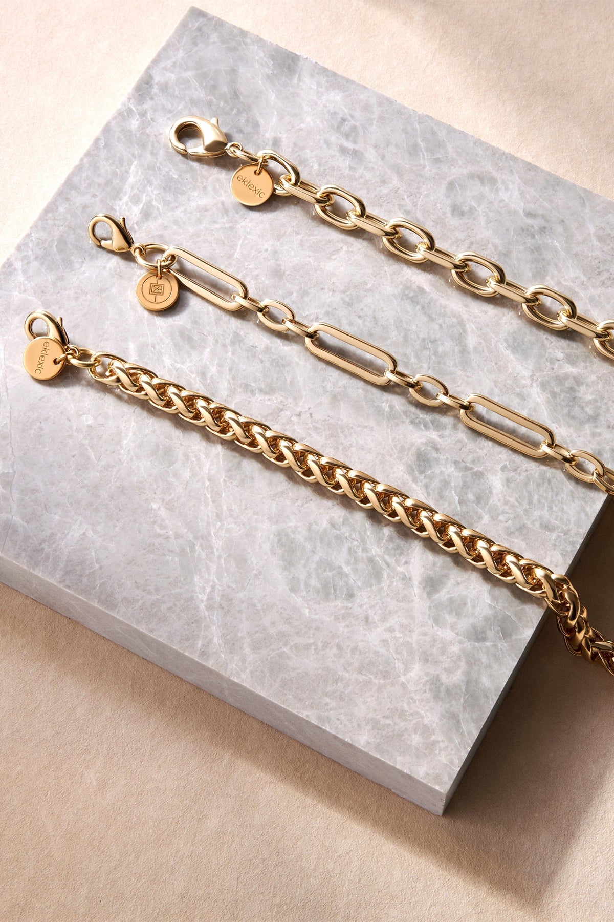 Esmé Bracelet with three shiny gold-toned chain bracelets on display