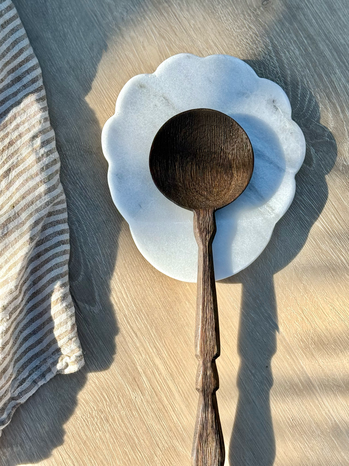 White marble spoon rest styled on a kitchen counter, adding natural texture and timeless elegance