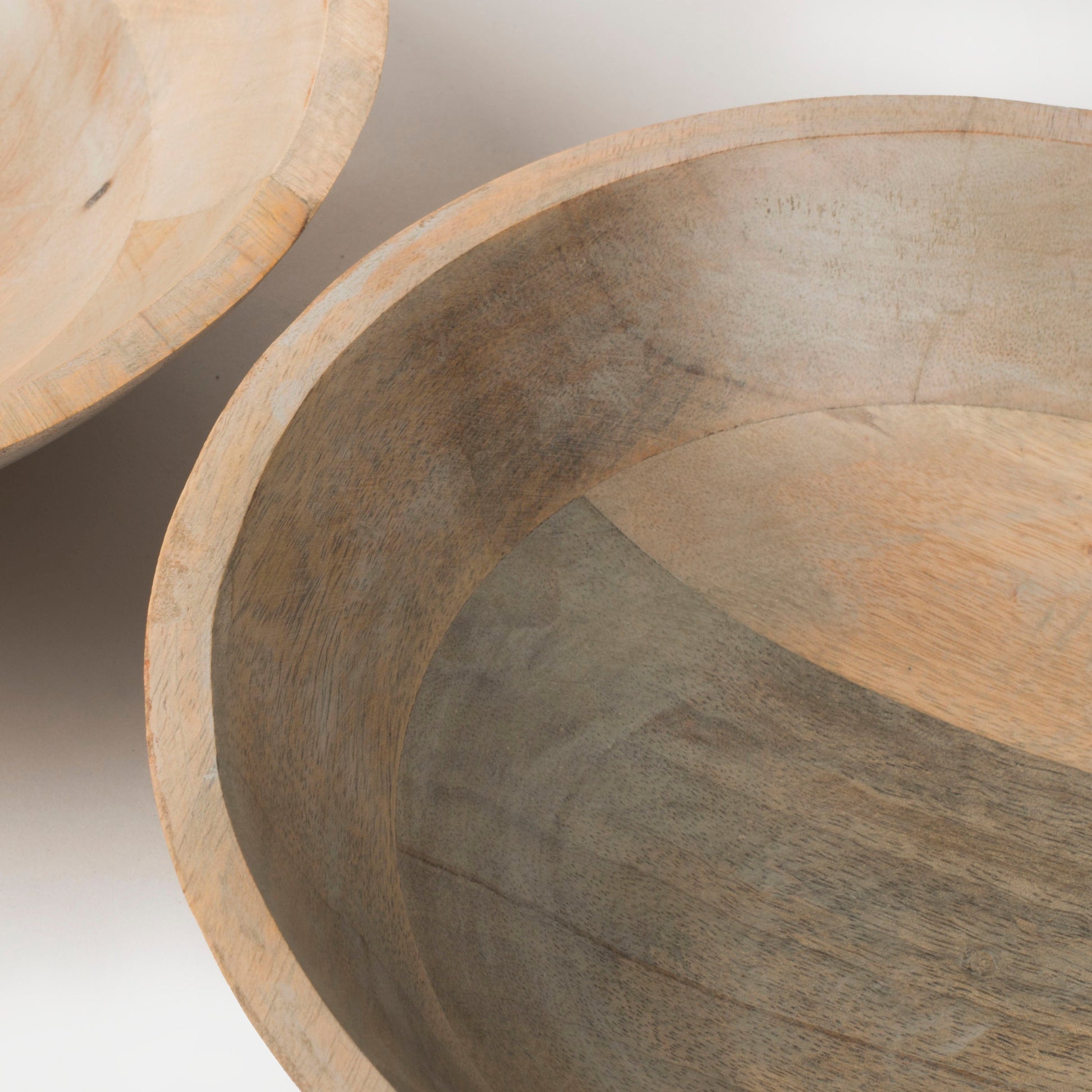 Two rustic grey mango wood bowls nested together to demonstrate space-saving, stackable kitchen storage.