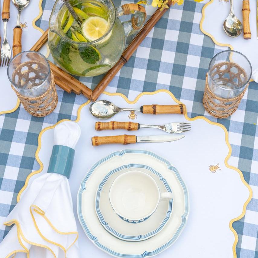 Bumble bee impermeable placemat with hand-stitched bee embroidery and yellow wavy border by Talah Home