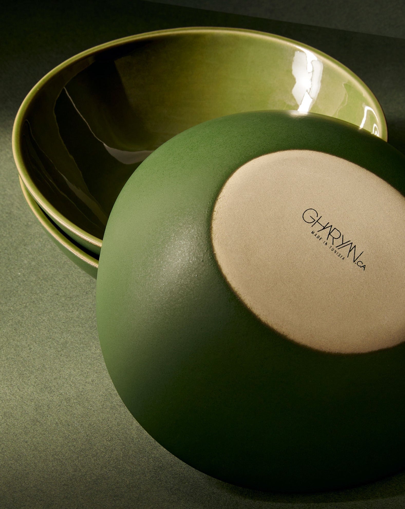 A beige stoneware soup plate with a matte finish, displayed alongside a white garlic bulb and a silver spoon, set against a neutral background with a textured napkin.