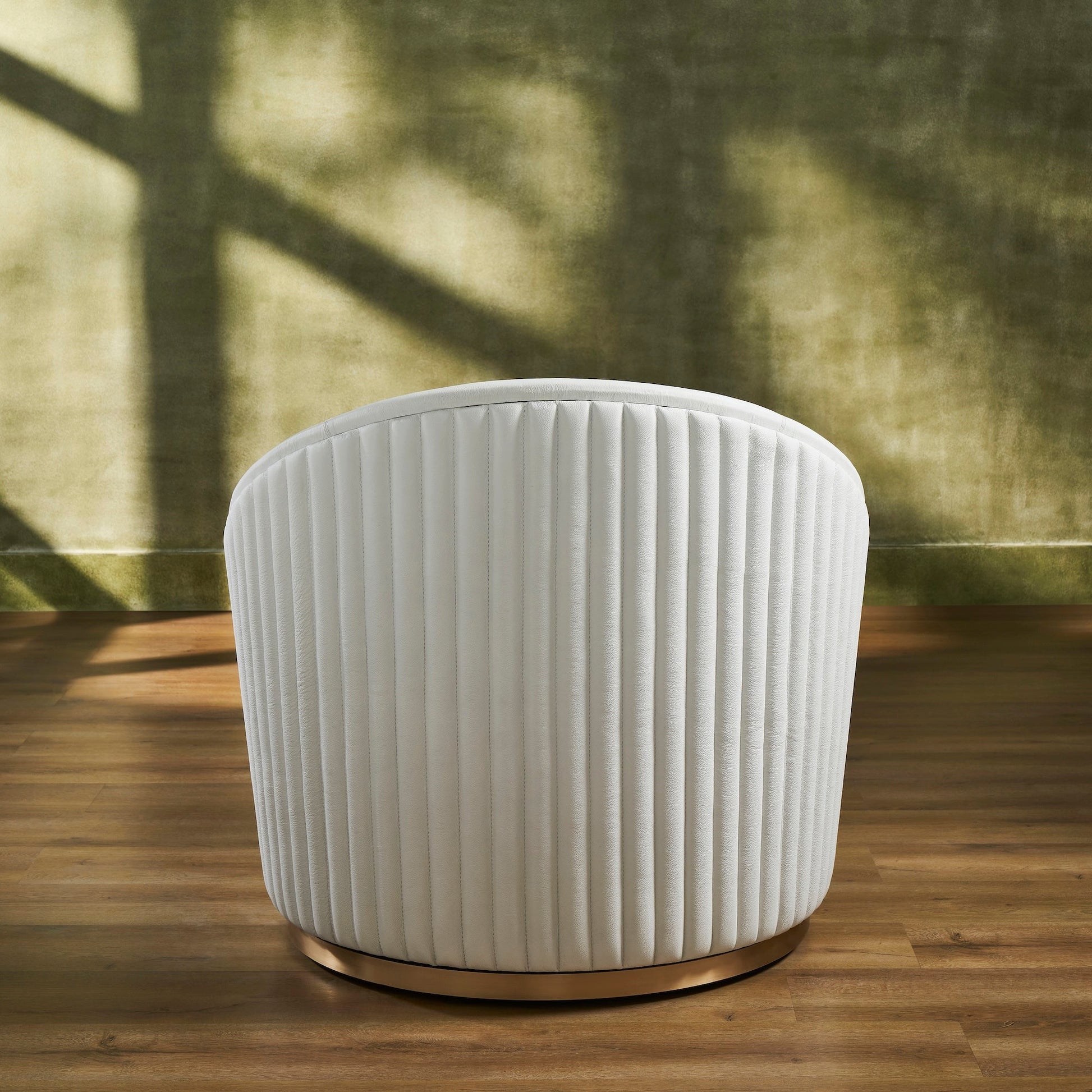 FN-5206-353529_5|Rear view of a sleek white leather swivel armchair, featuring striking vertical ribbed back detailing and a polished gold base.