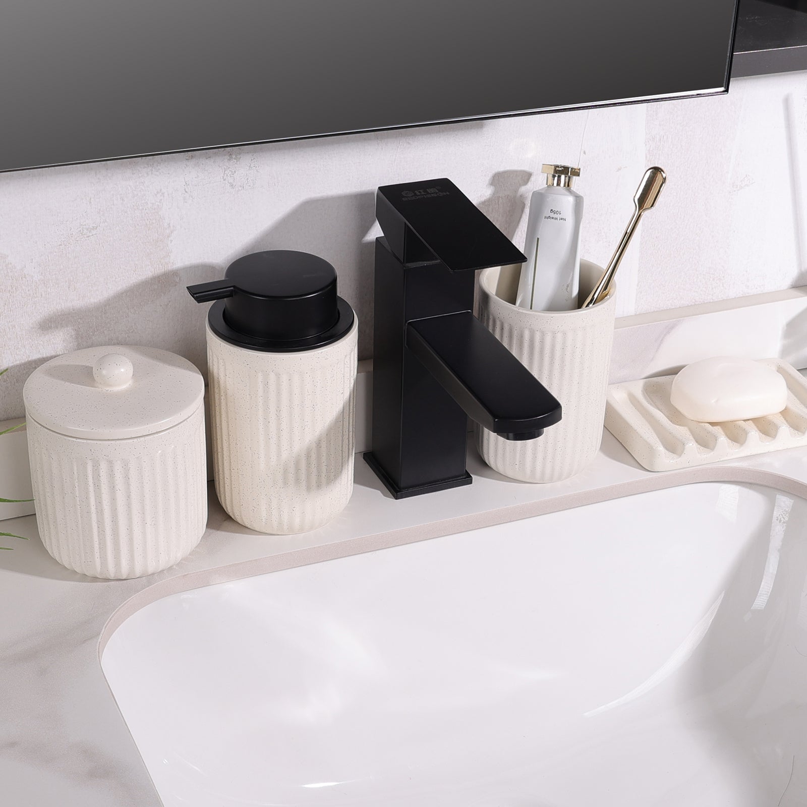 Lifestyle shot of the 4-piece BosilunLife Pockmark bathroom set in speckled white recycled eco-clay, arranged around a modern matte black faucet. The set includes a foaming soap dispenser, toothbrush holder, lidded storage canister, and wave soap dish, showcasing a minimalist, sustainable bathroom aesthetic.